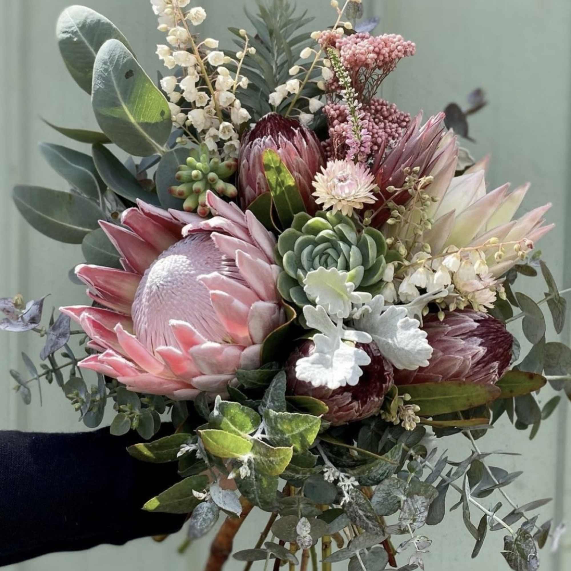 Hand-tied bouquet with pink protea and succulents