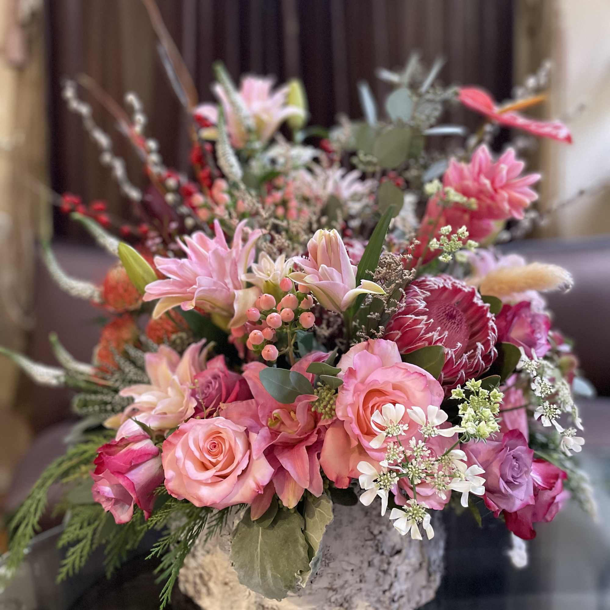 Pink mixed bouquet in a rustic round container