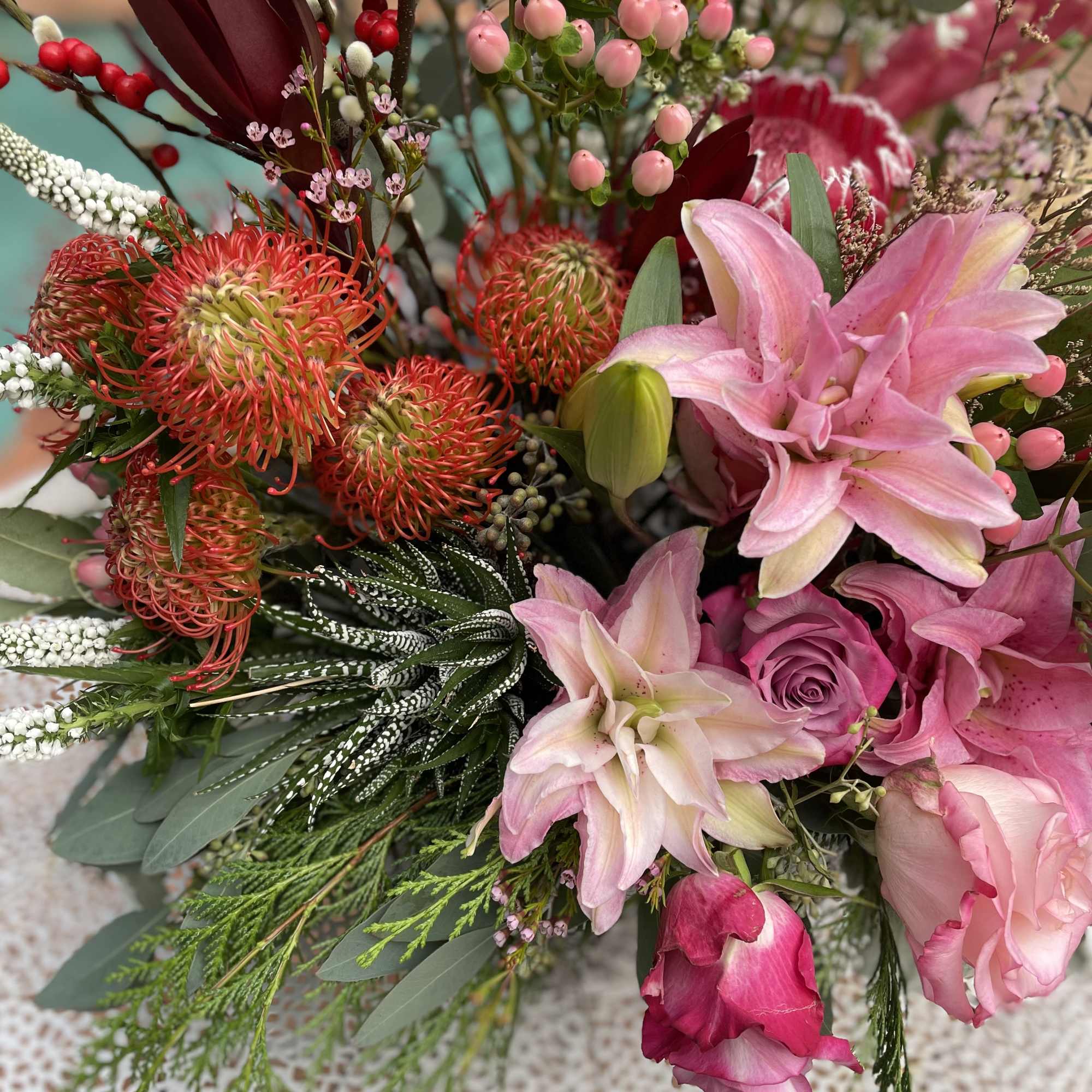 Pink and red mixed bouquet with lilies, roses, and berries