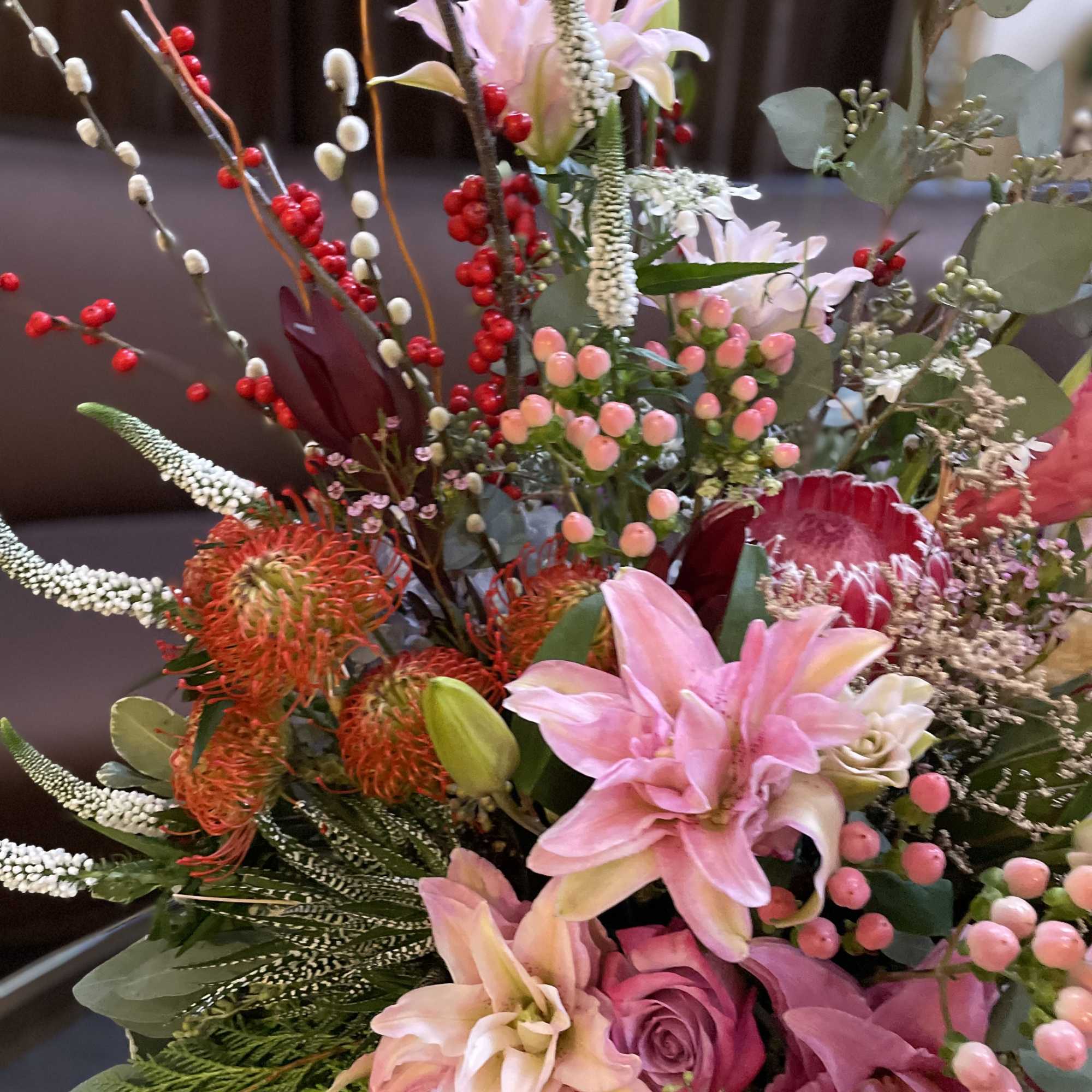 Mixed bouquet with pink lilies, roses, and red berries