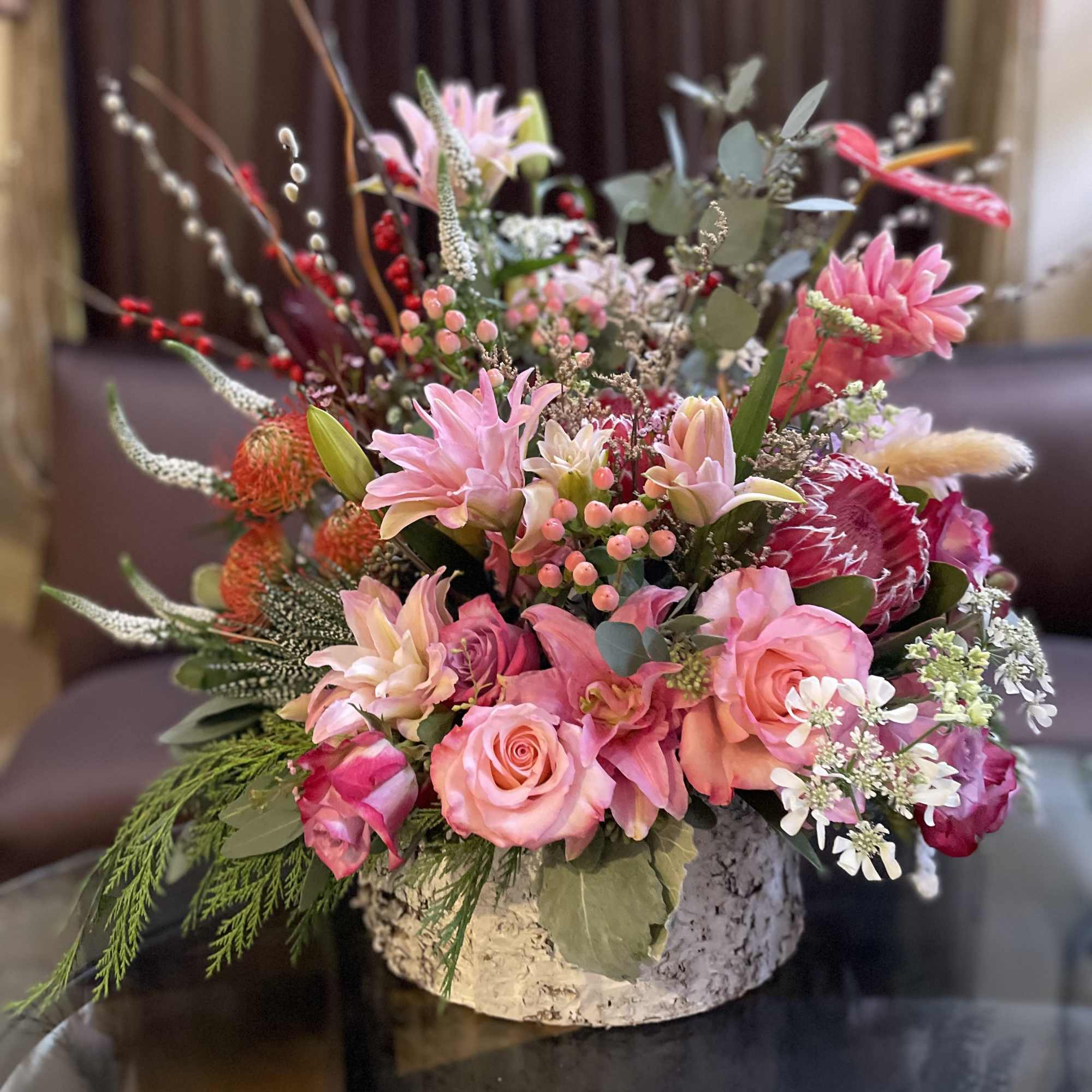 Pink and peach floral arrangement in a low round container