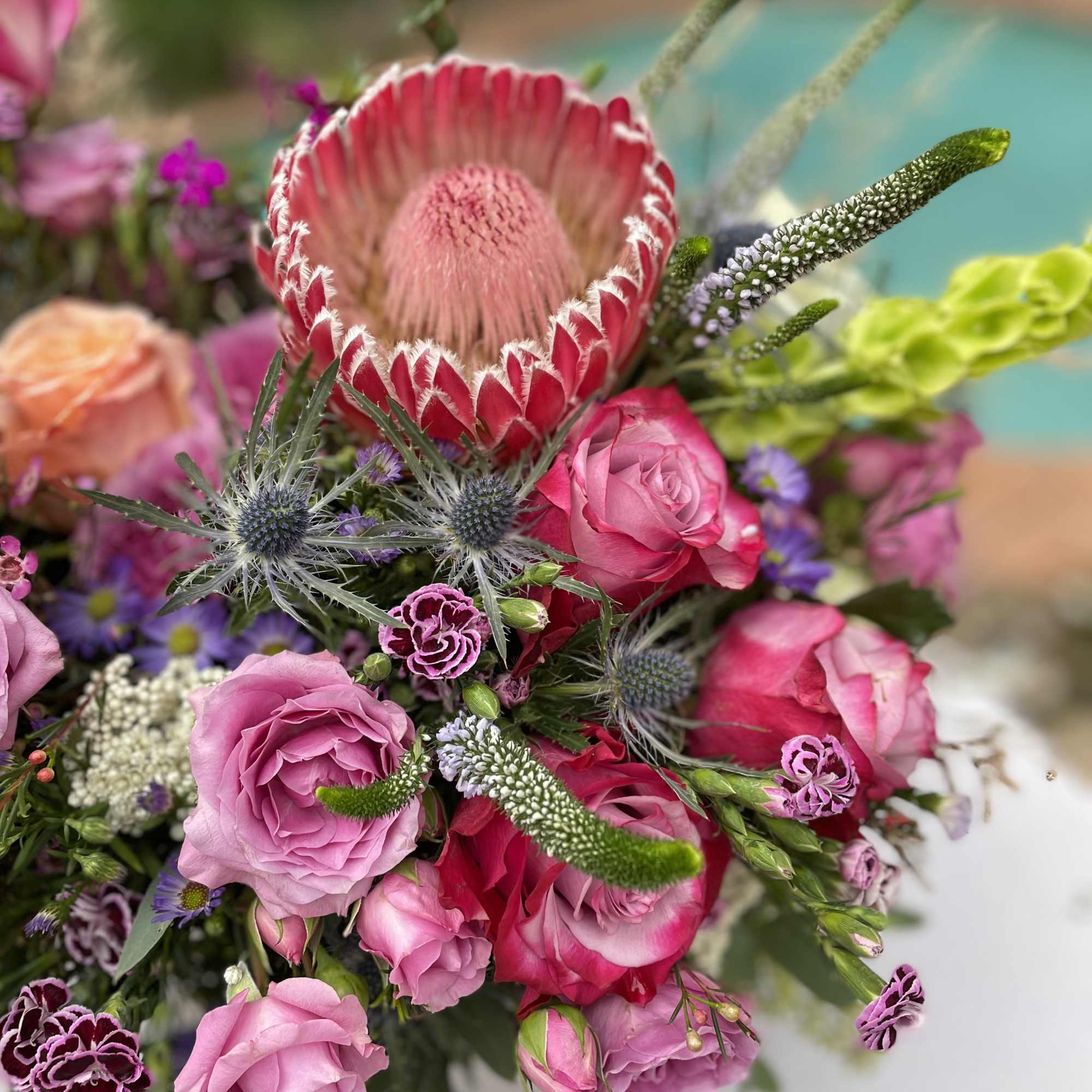 Pink and red bouquet with a large protea and roses