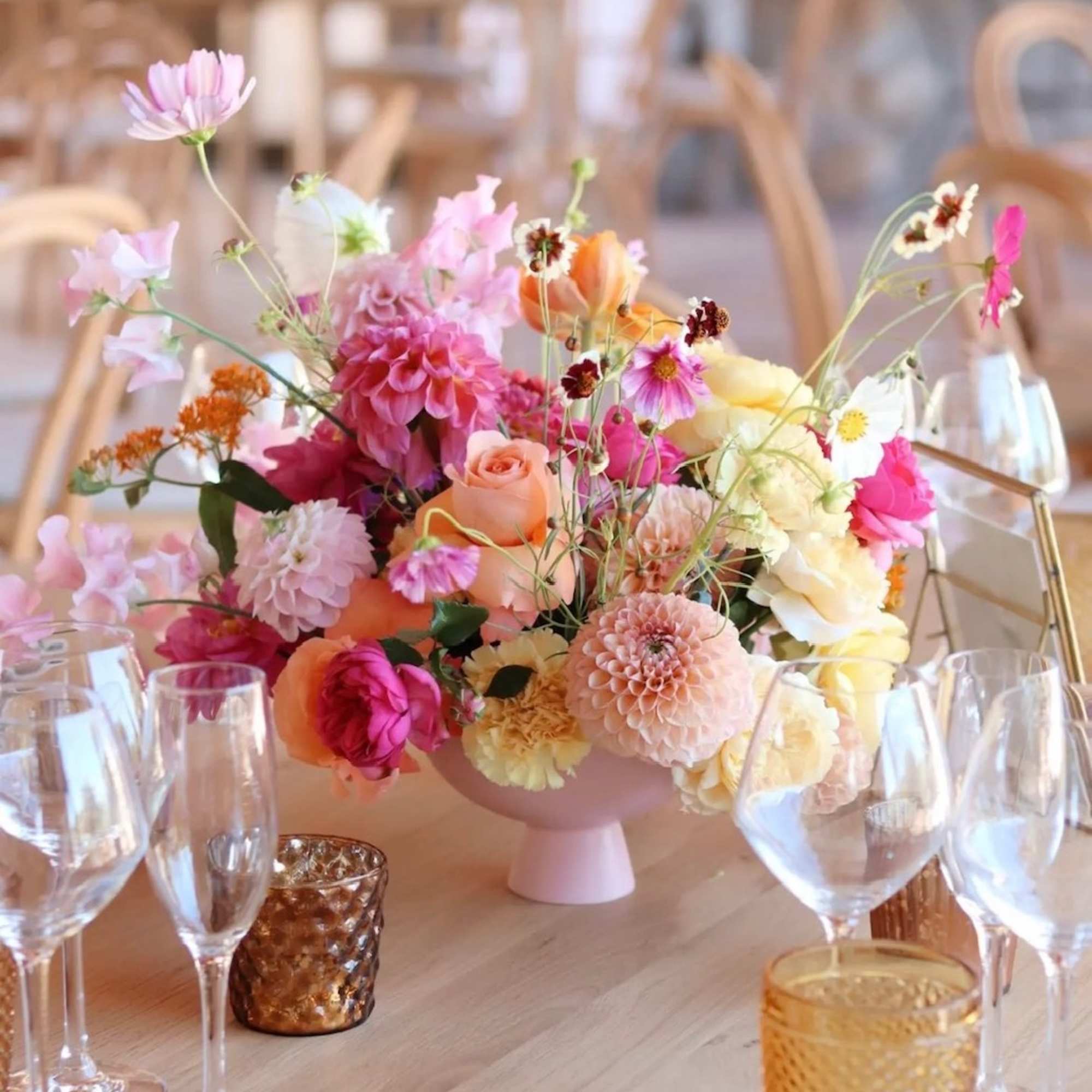 Pastel floral centerpiece in a pink vase on a table