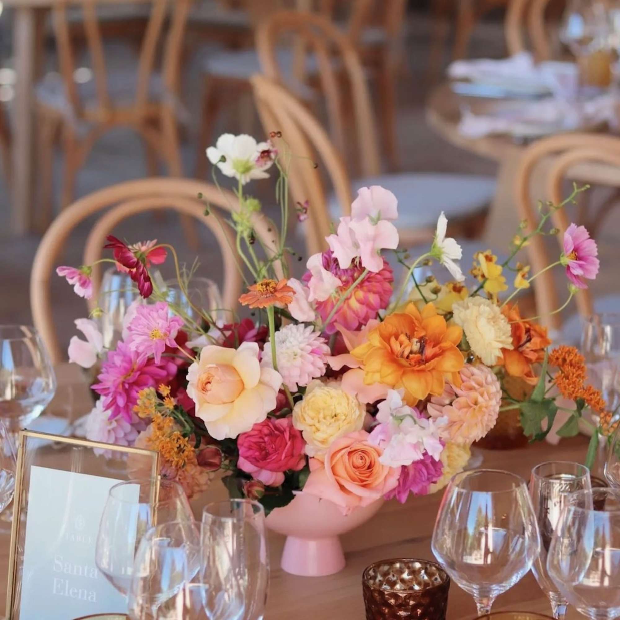 Colorful floral centerpiece in a pink vase on a banquet table