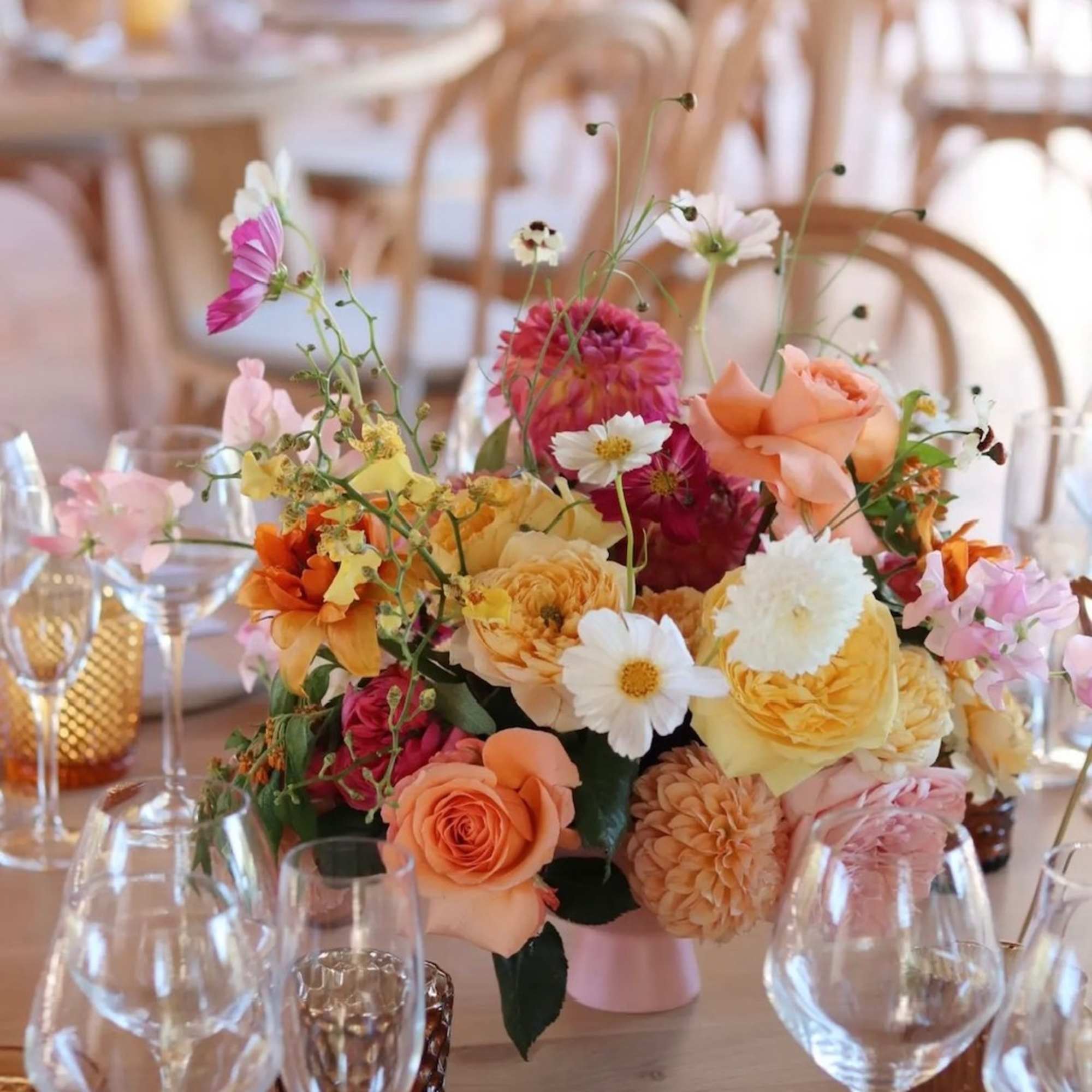 Colorful floral centerpiece in a low vase on a set dining table