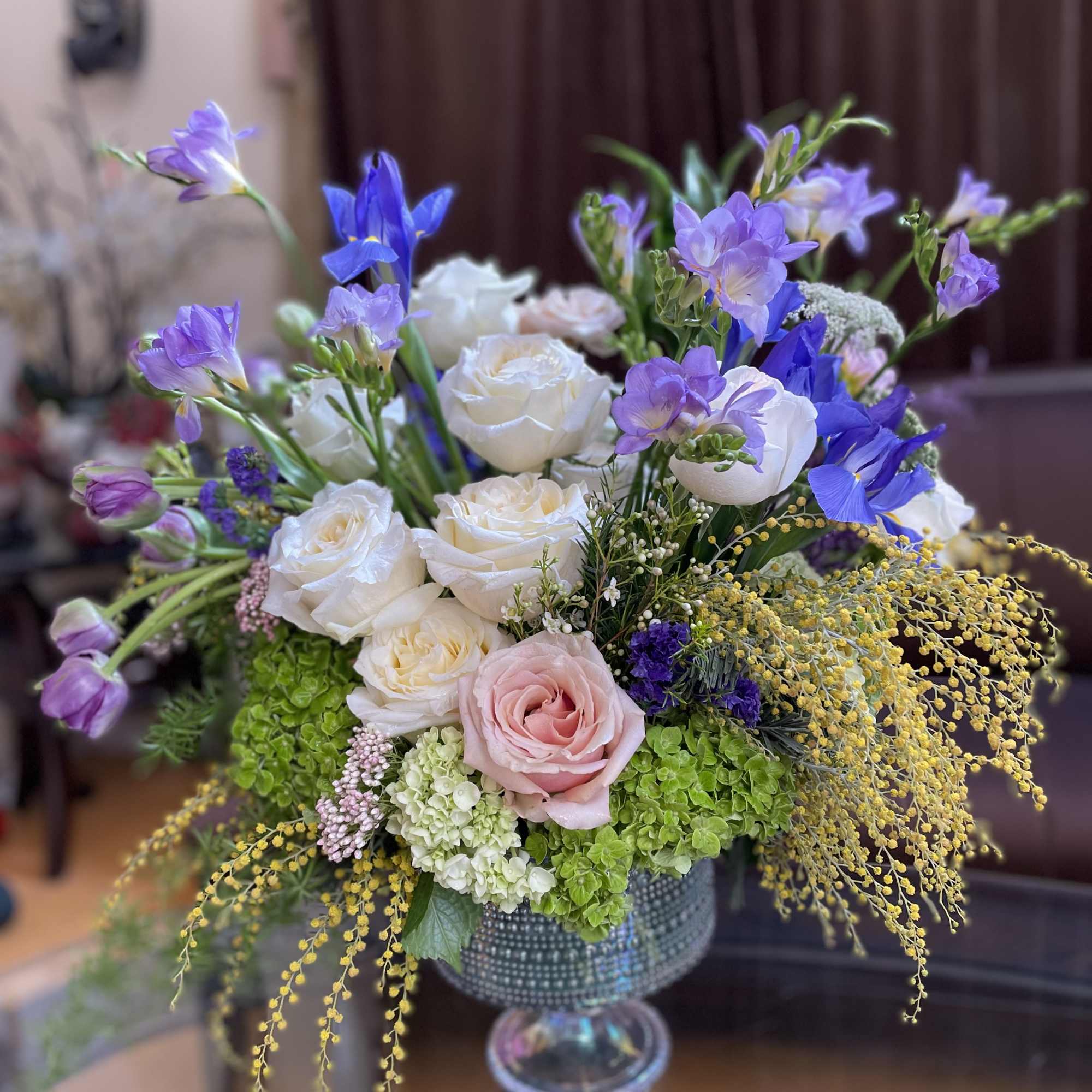 Bouquet of white and pink roses with purple flowers in a glass vase
