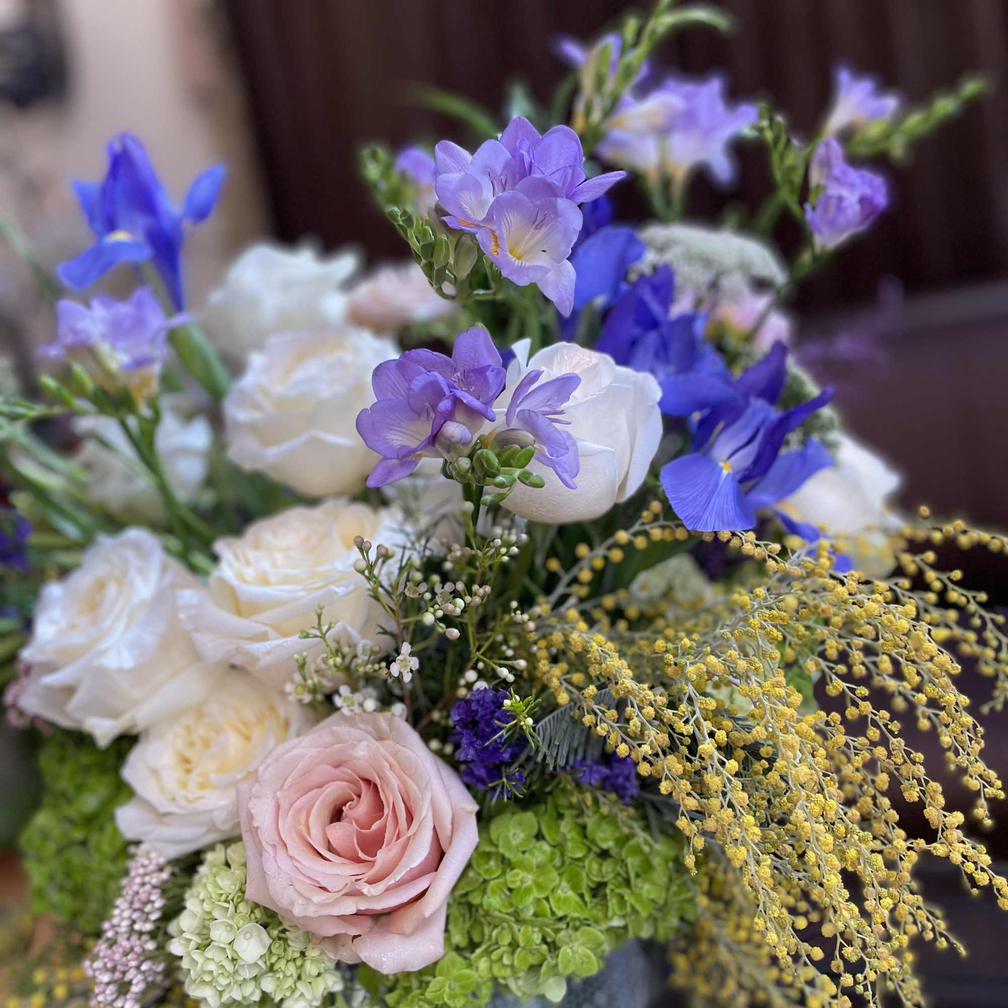 Bouquet of white and pink roses with purple blooms in a vase