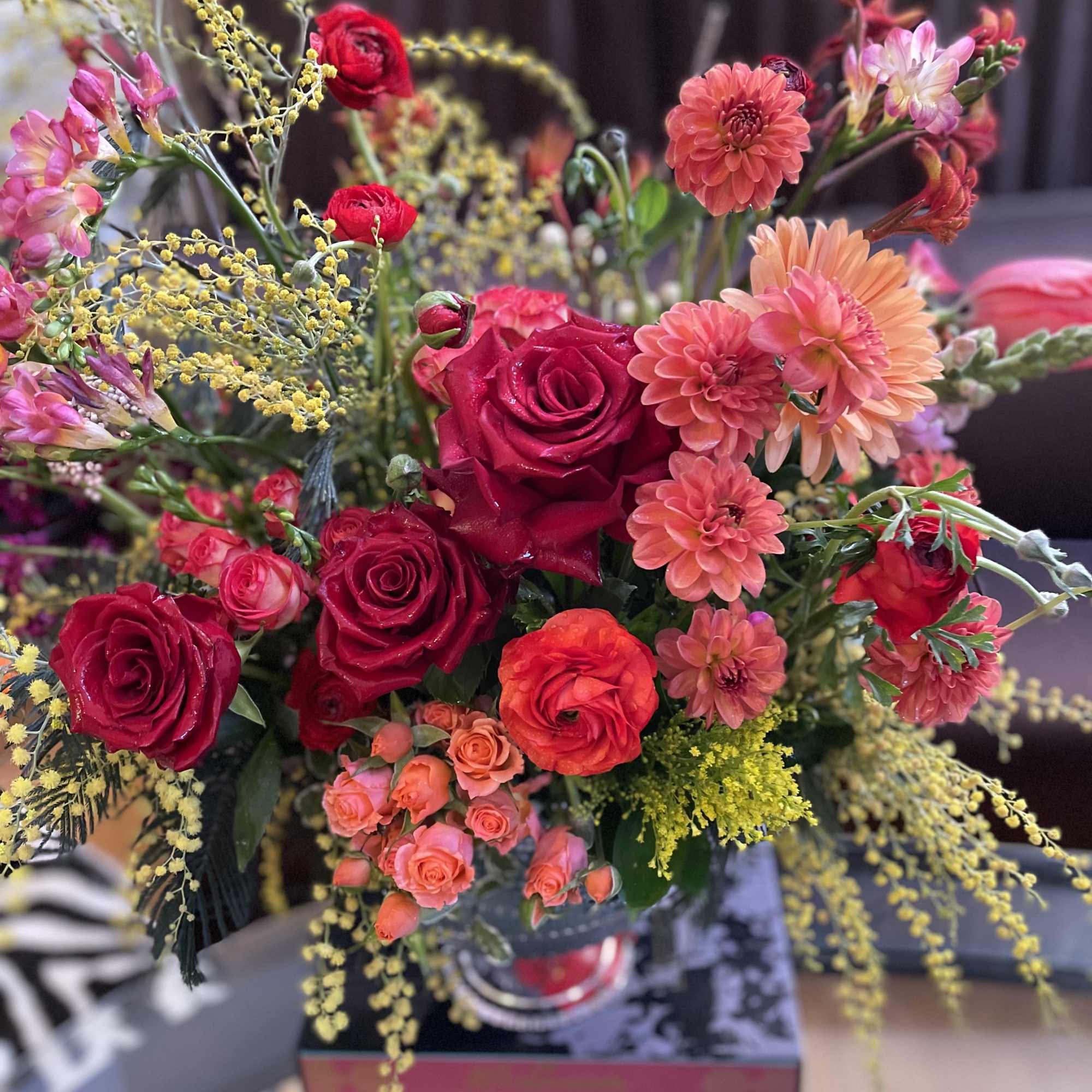 Bouquet of red roses and coral dahlias with yellow filler flowers
