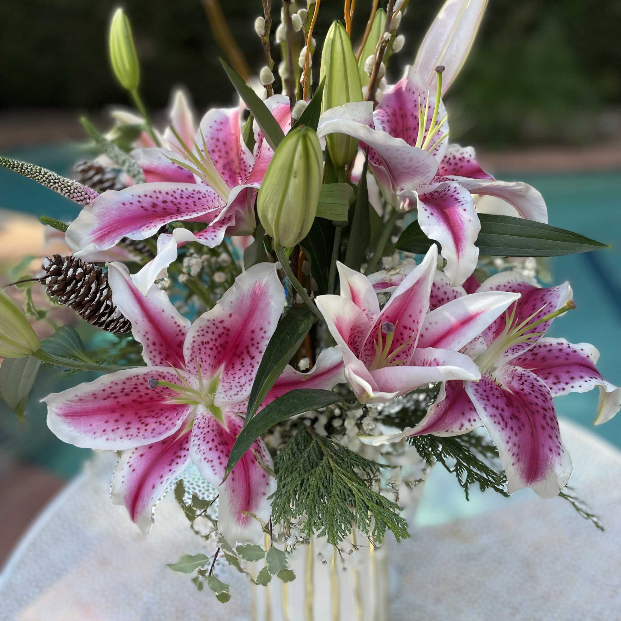 Pink and white lilies arranged in a striped vase