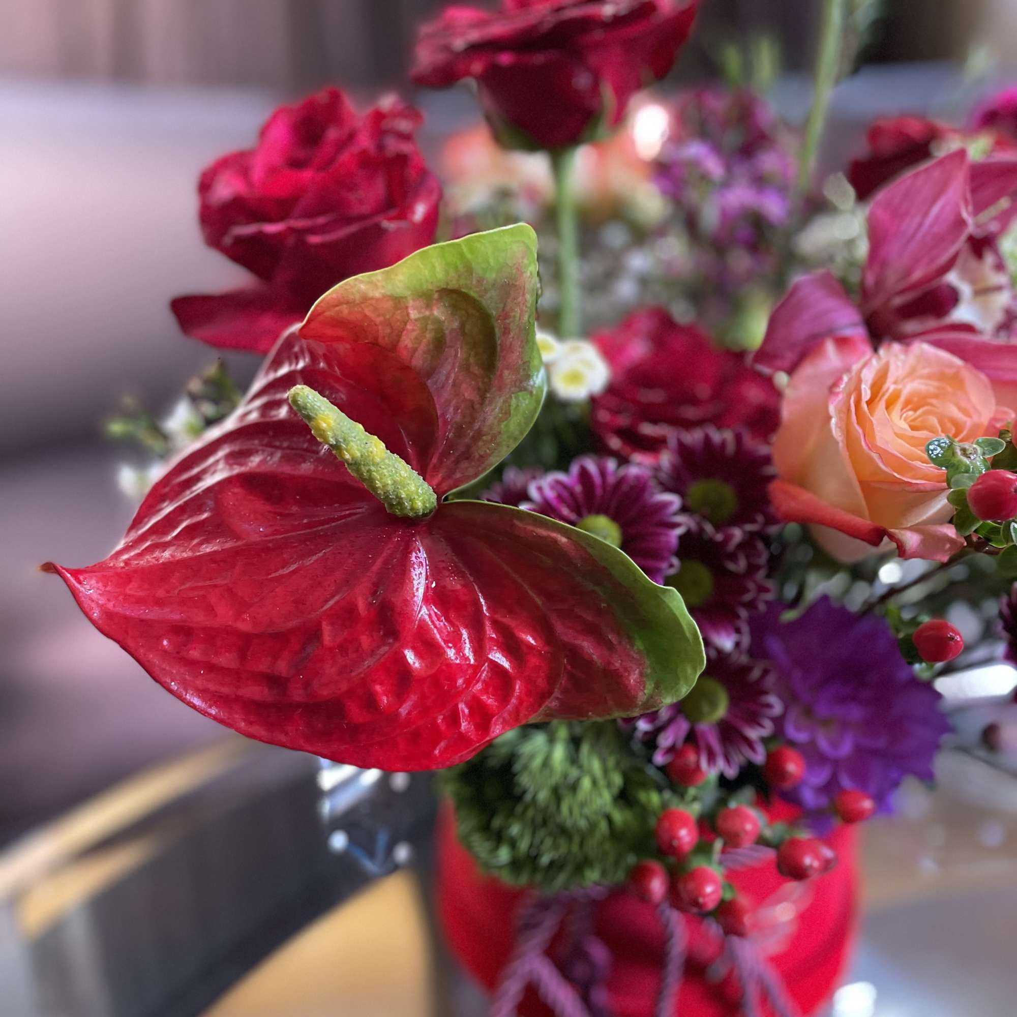 Red anthurium and mixed flowers in a red container