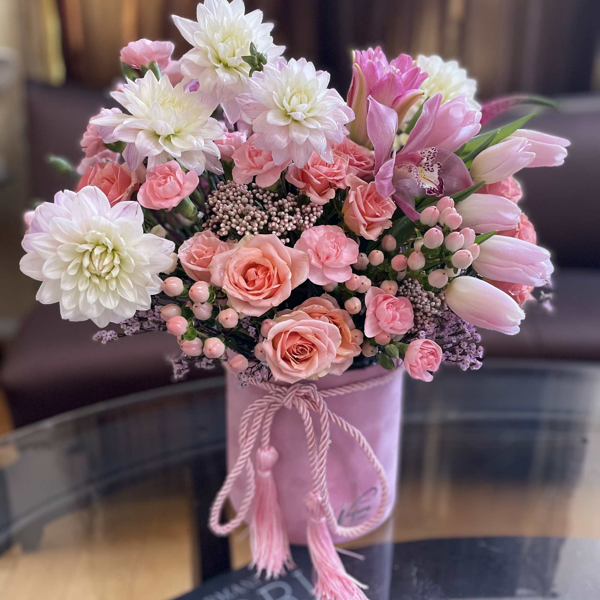 Pink and white bouquet in a pink hatbox with tassel cord
