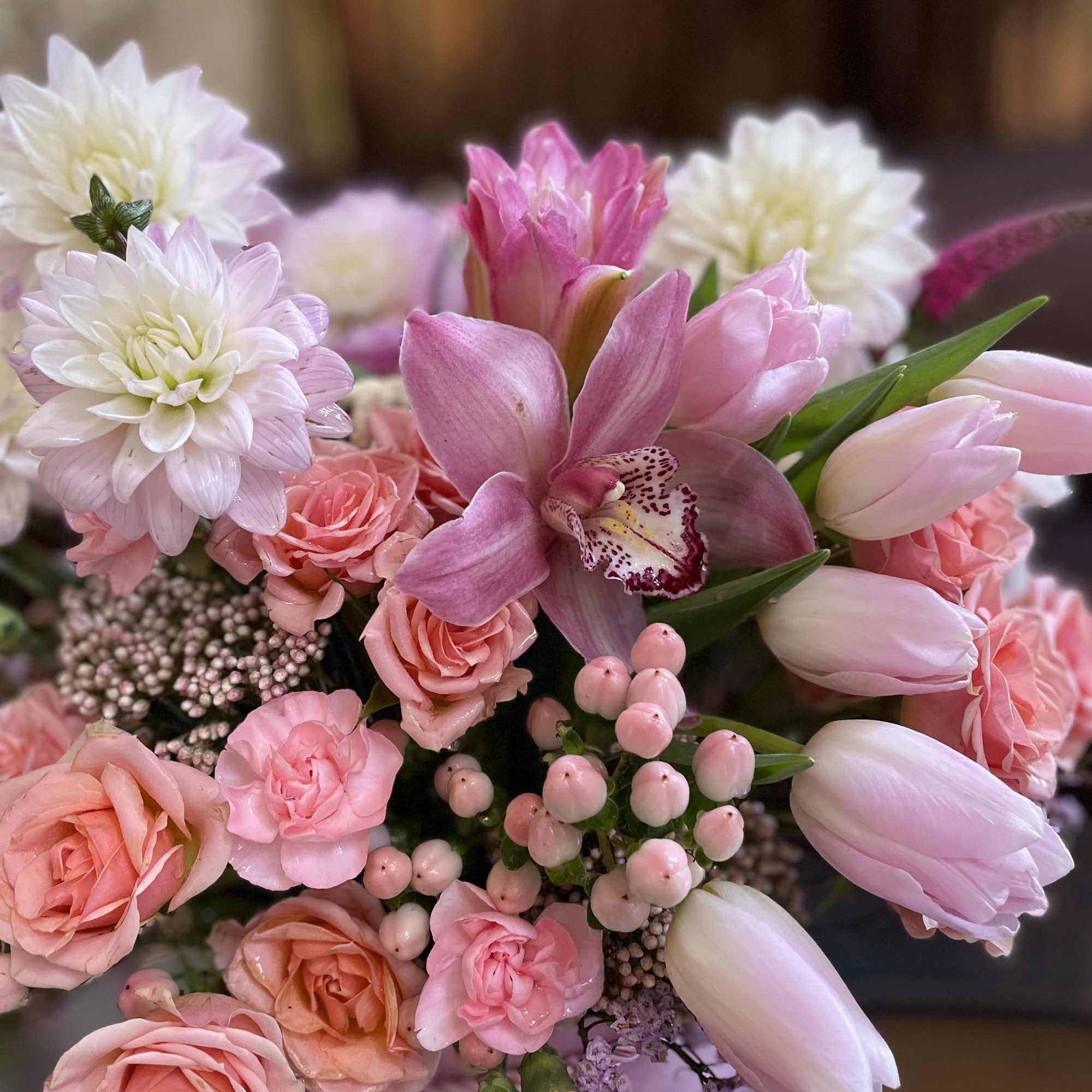 Pink bouquet with roses, tulips, and a central orchid