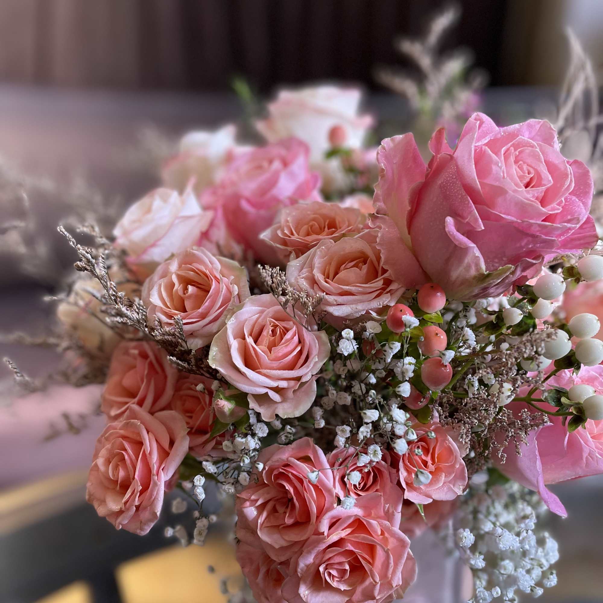 Pink and peach roses arranged in a bouquet with baby's breath