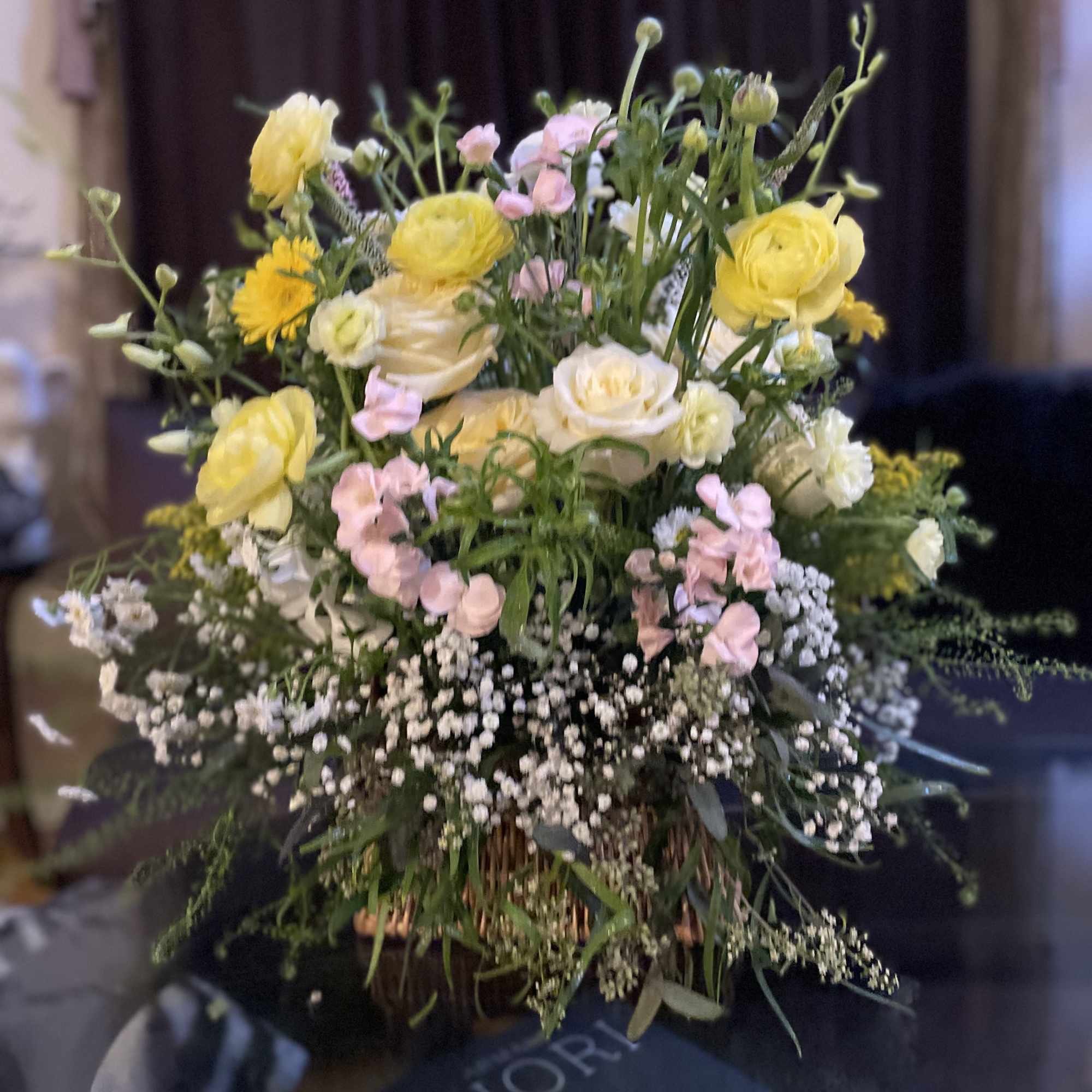 Yellow and pink mixed flower arrangement in a basket