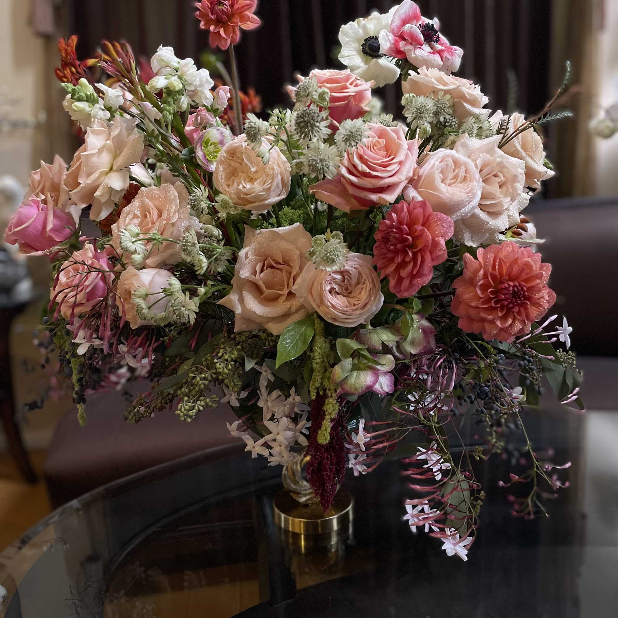 Mixed pink and peach floral arrangement in a gold vase