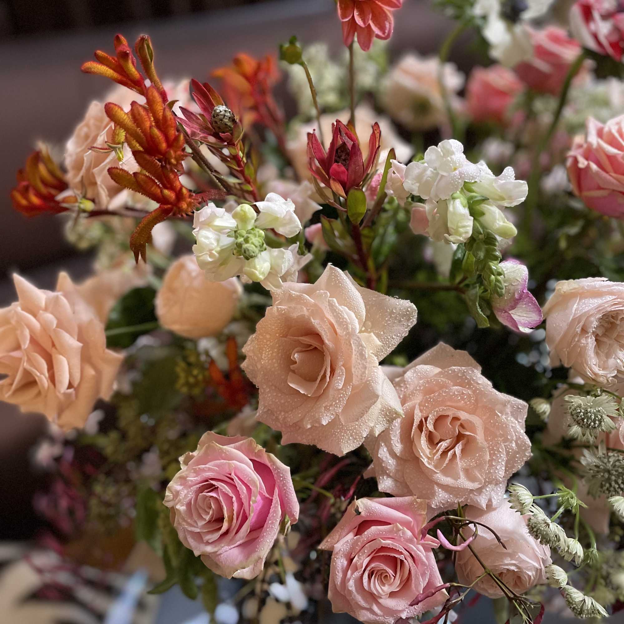 Bouquet of blush and pink roses with orange and white accent flowers