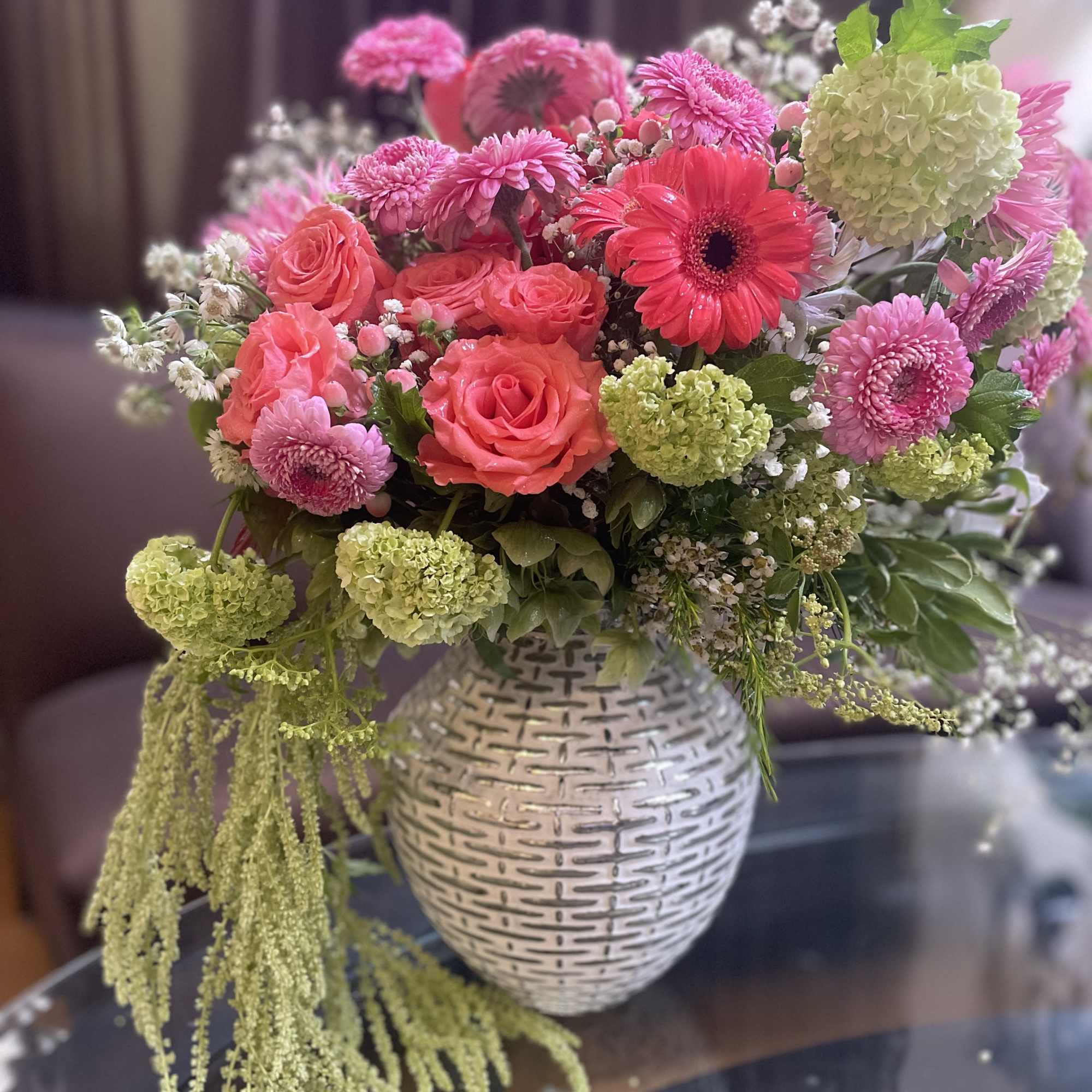 Pink and coral mixed bouquet in a white textured vase