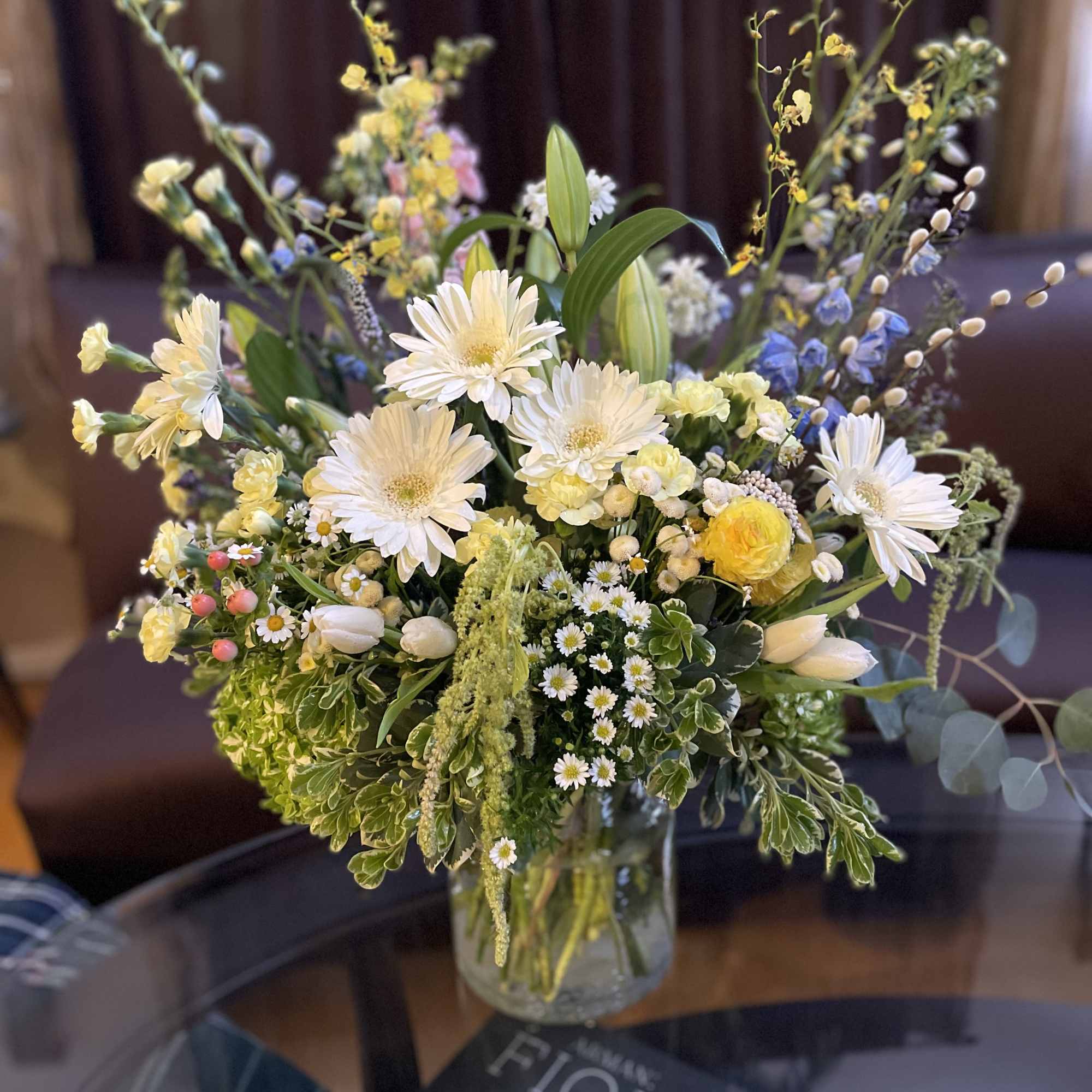 Mixed bouquet of white and yellow flowers in a glass vase