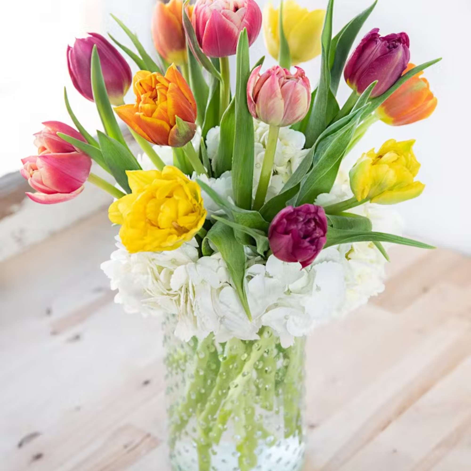 Colorful tulips arranged in a clear glass vase