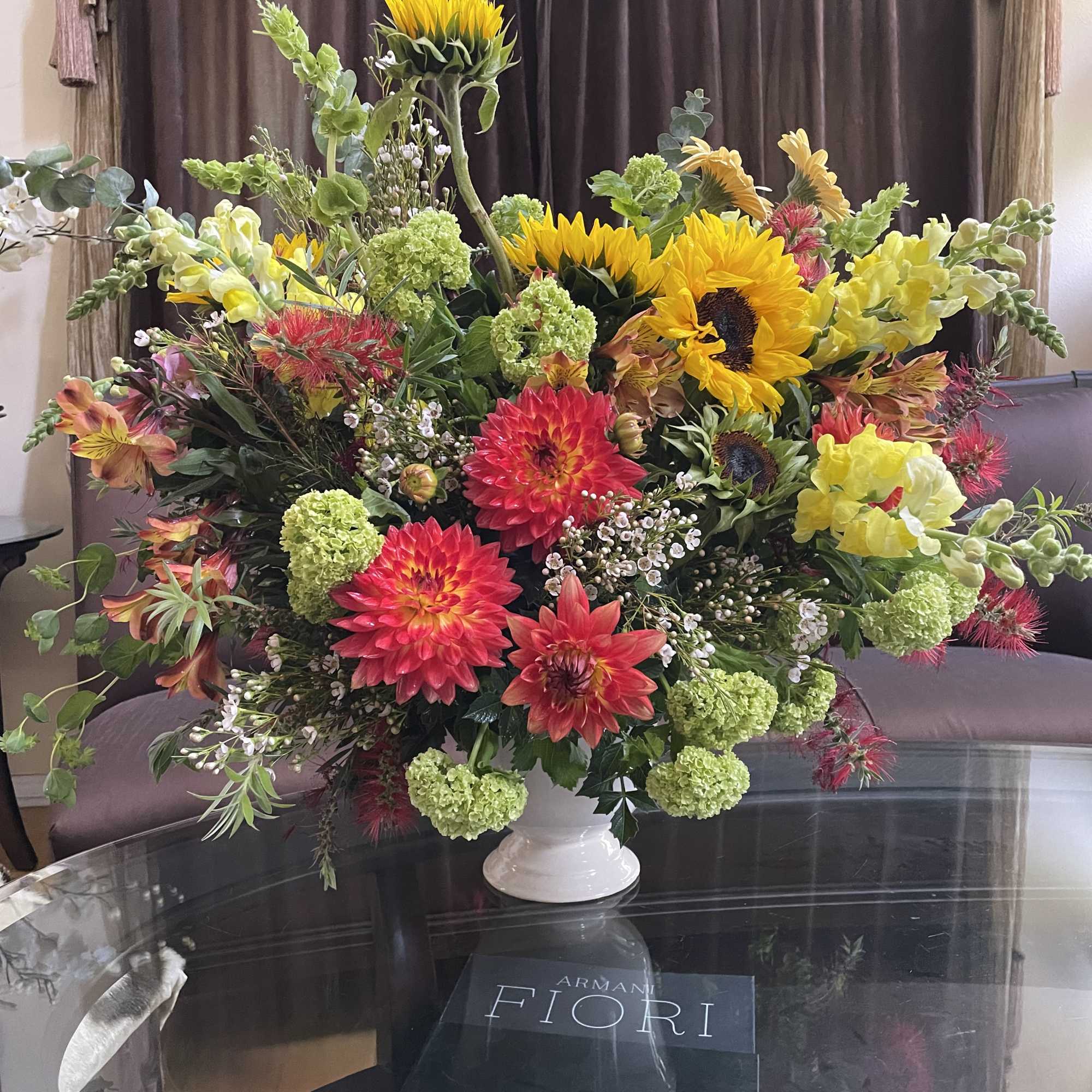 Large mixed bouquet with sunflowers, dahlias, and snapdragons in a white vase