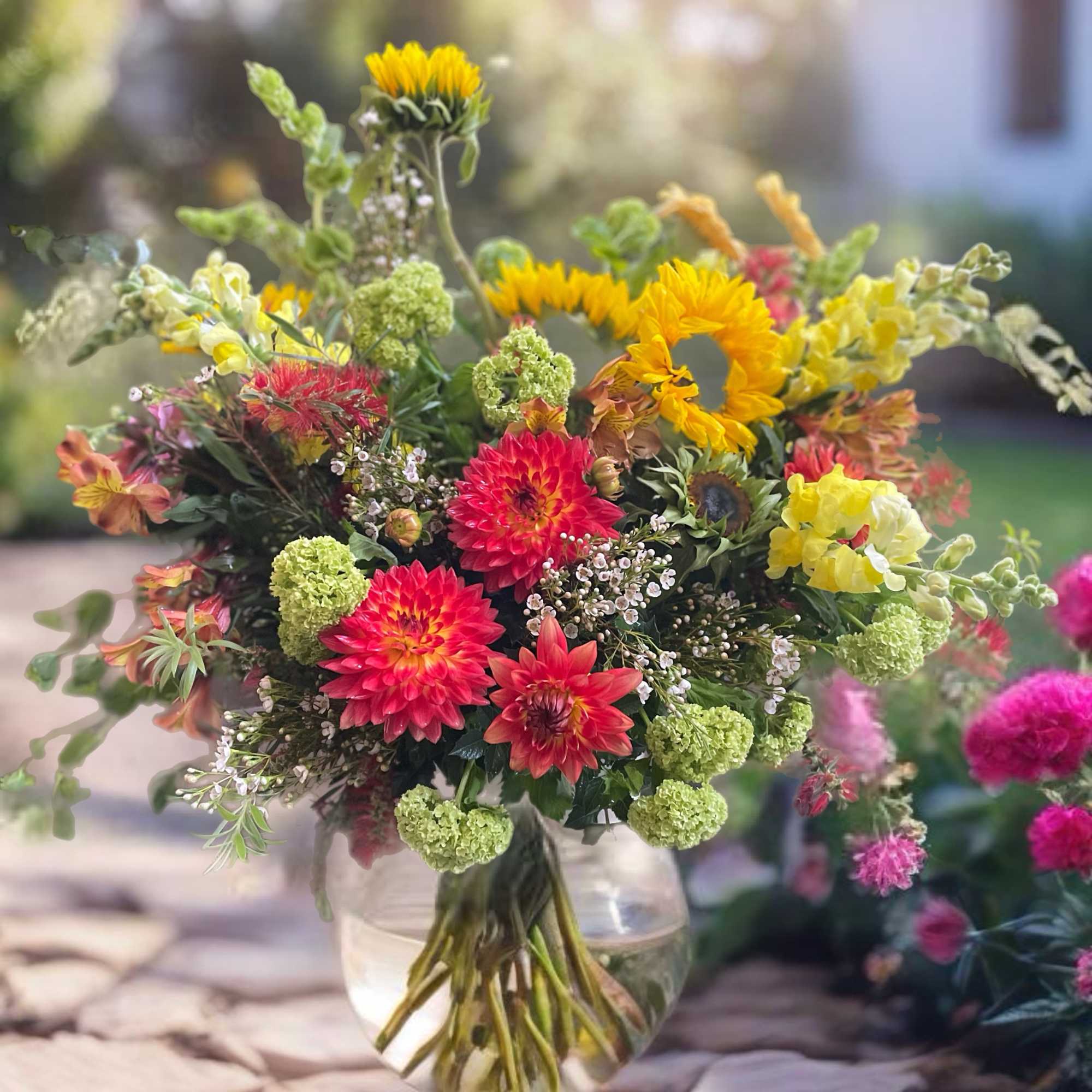 Bright mixed bouquet in a clear glass vase with yellow and pink blooms