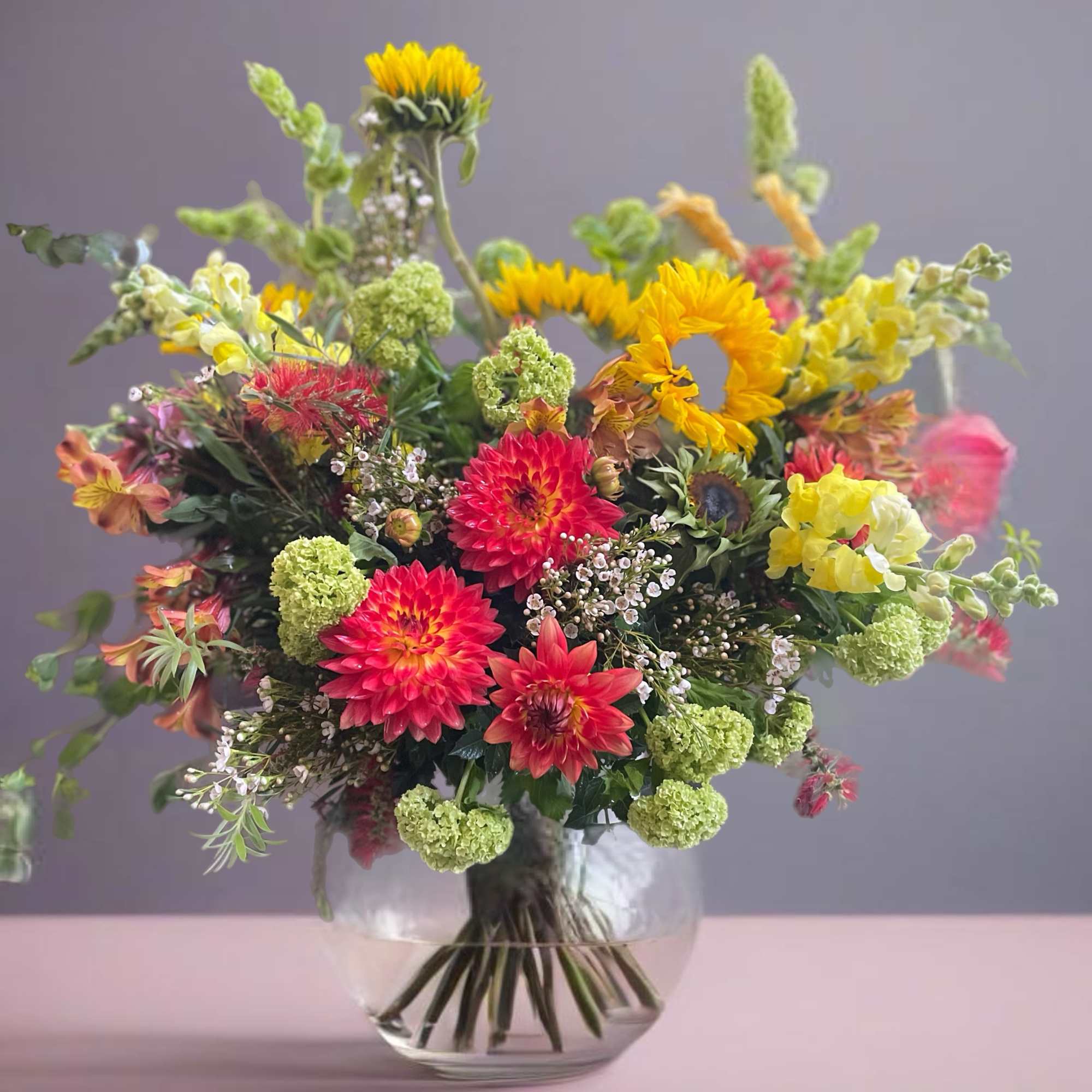 Mixed bouquet of bright flowers in a clear glass vase