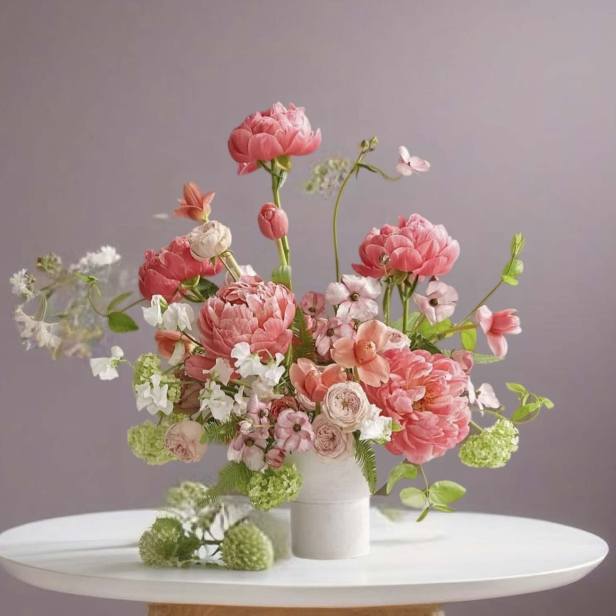 Pink and peach floral arrangement in a white vase