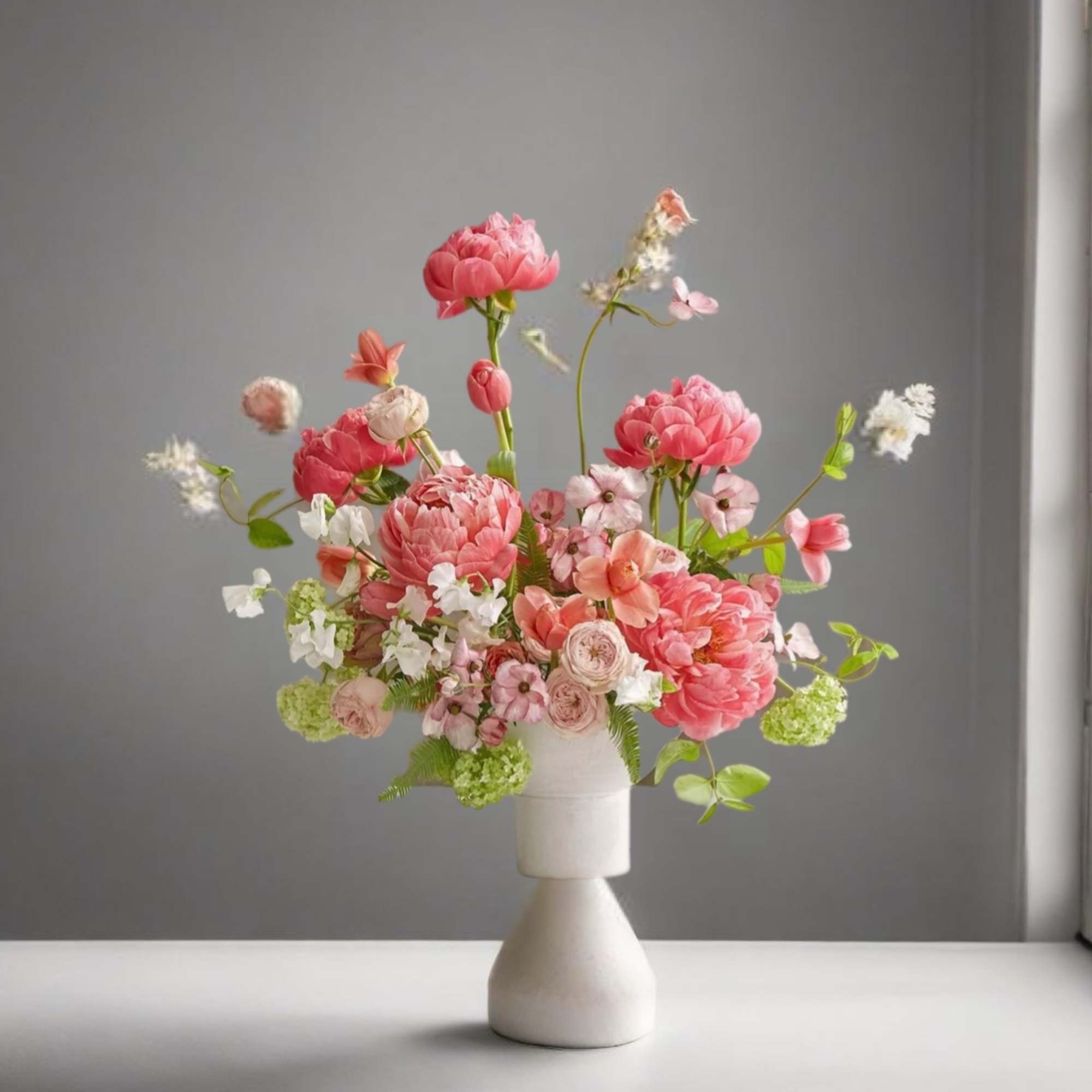 Pink and white floral arrangement in a white vase