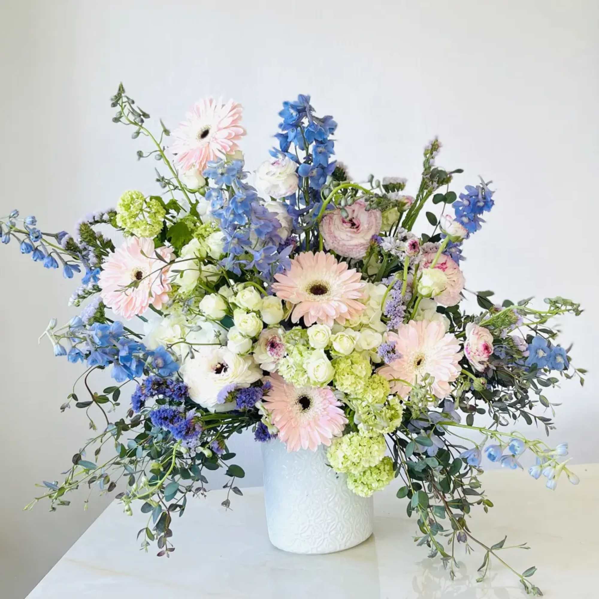 Pastel mixed flower arrangement in a white vase, photo 4 of 5