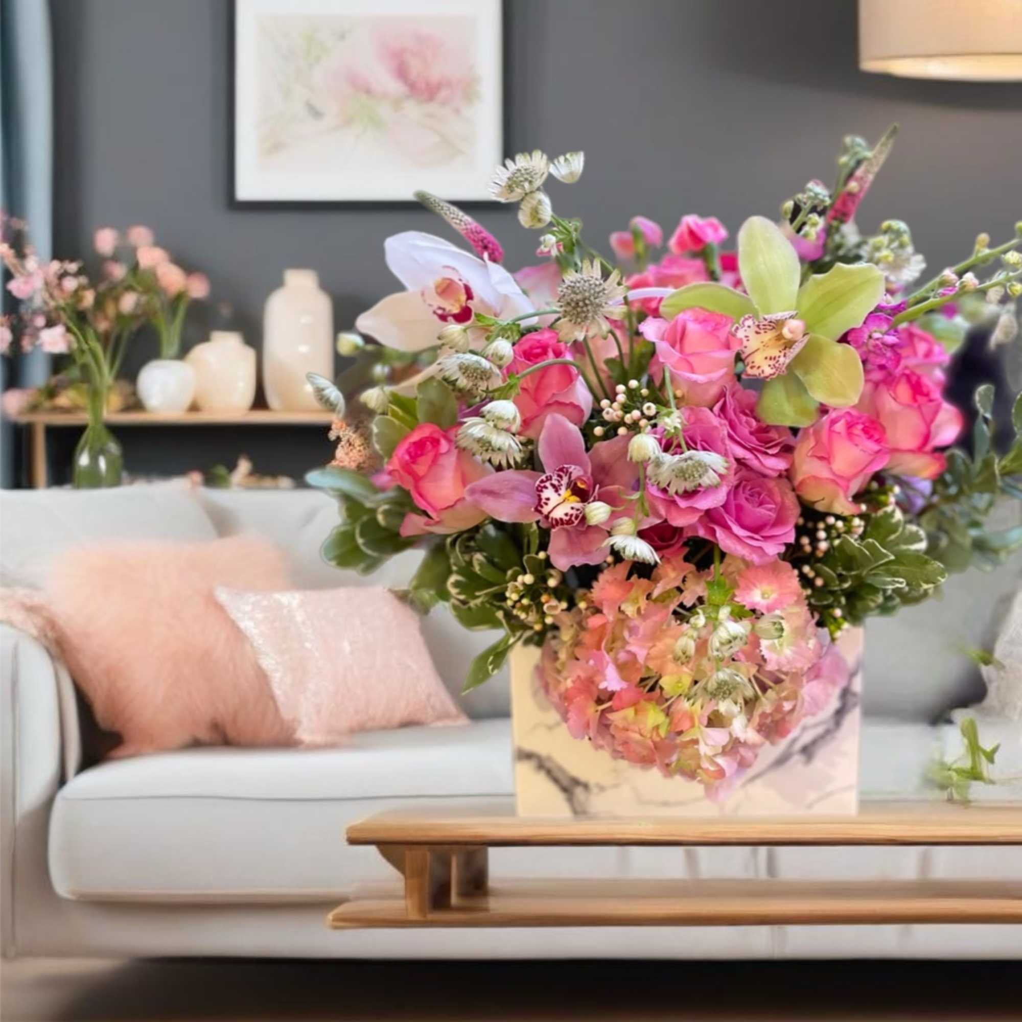 Pink and peach floral arrangement in a marble-patterned box