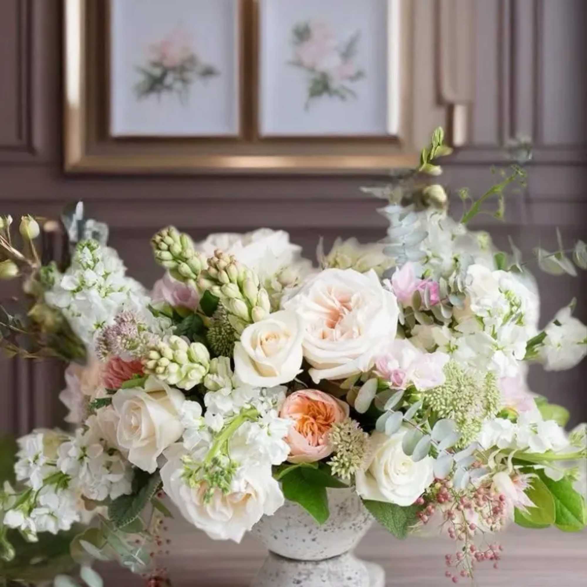 Pastel floral arrangement in a white pedestal vase