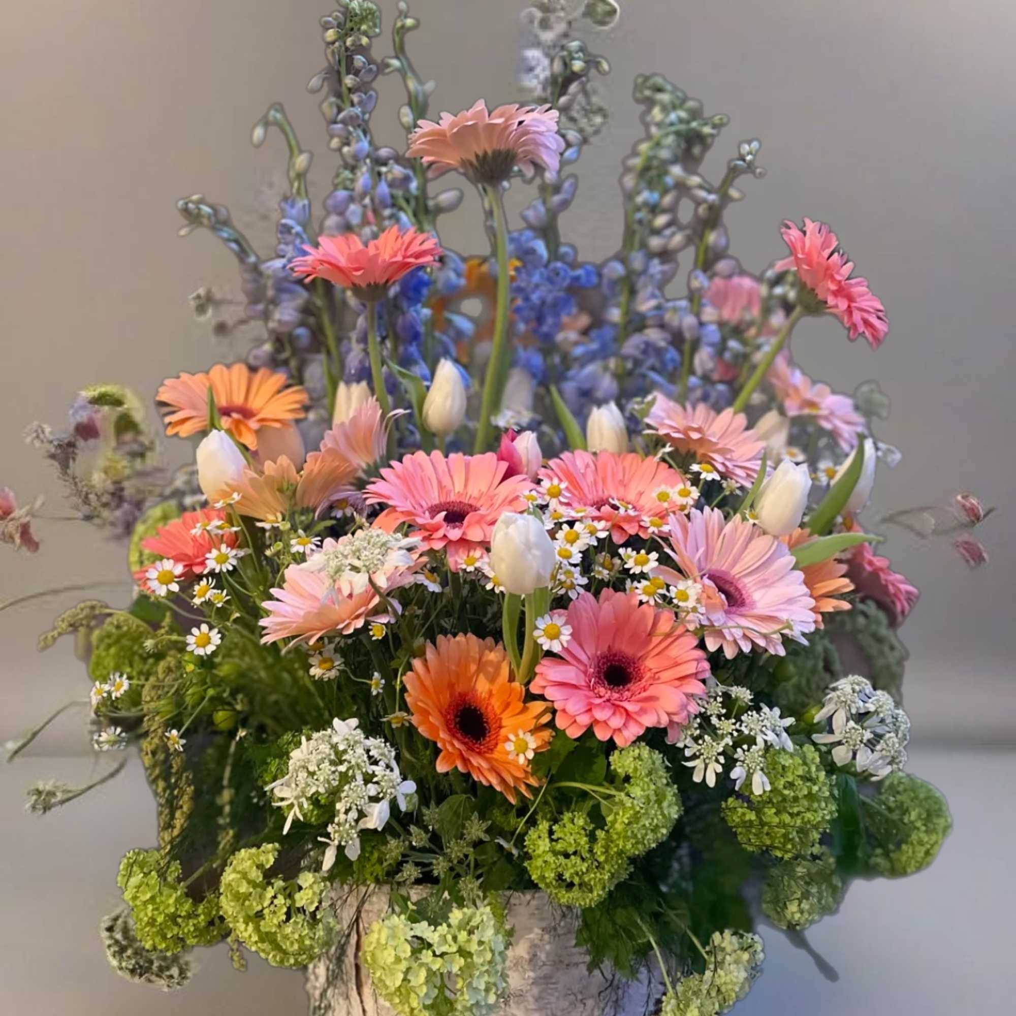 Mixed bouquet of pink and orange daisies in a rustic container, photo 2 of 4