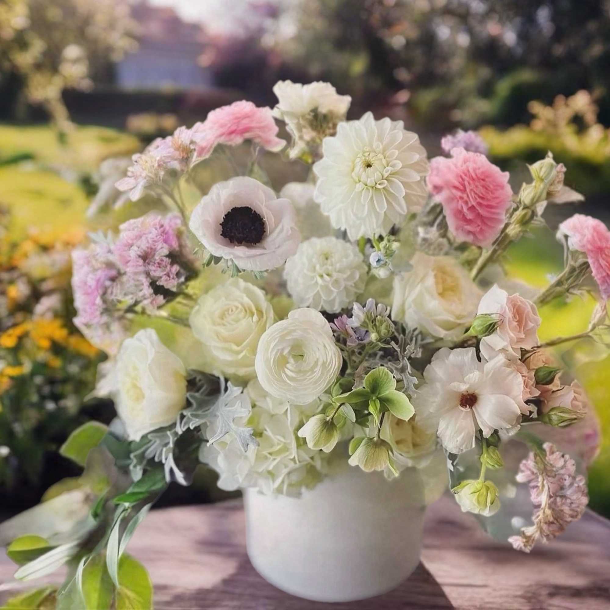 Pastel bouquet of white and pink flowers in a white vase