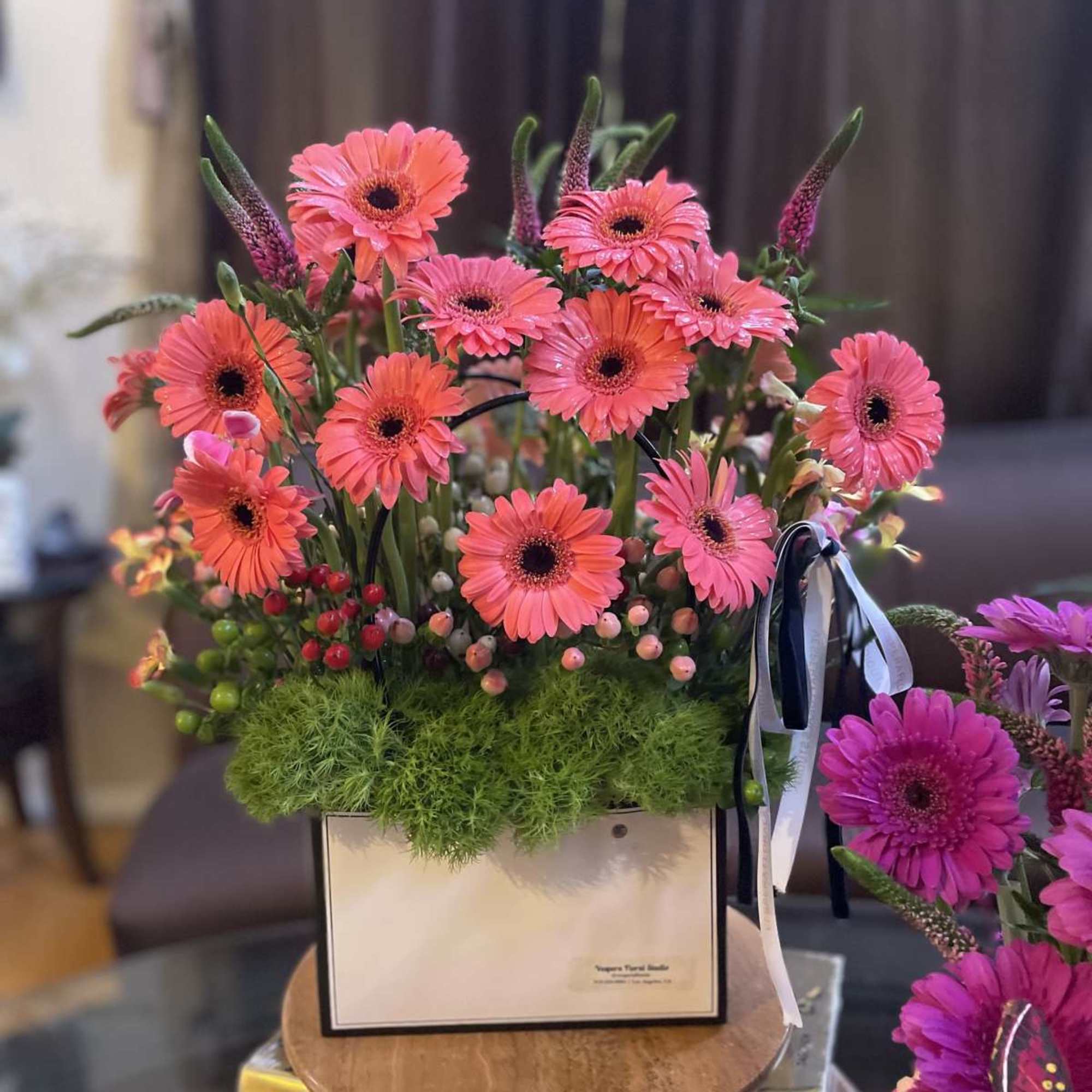 Pink gerbera daisy arrangement in a white box with ribbon