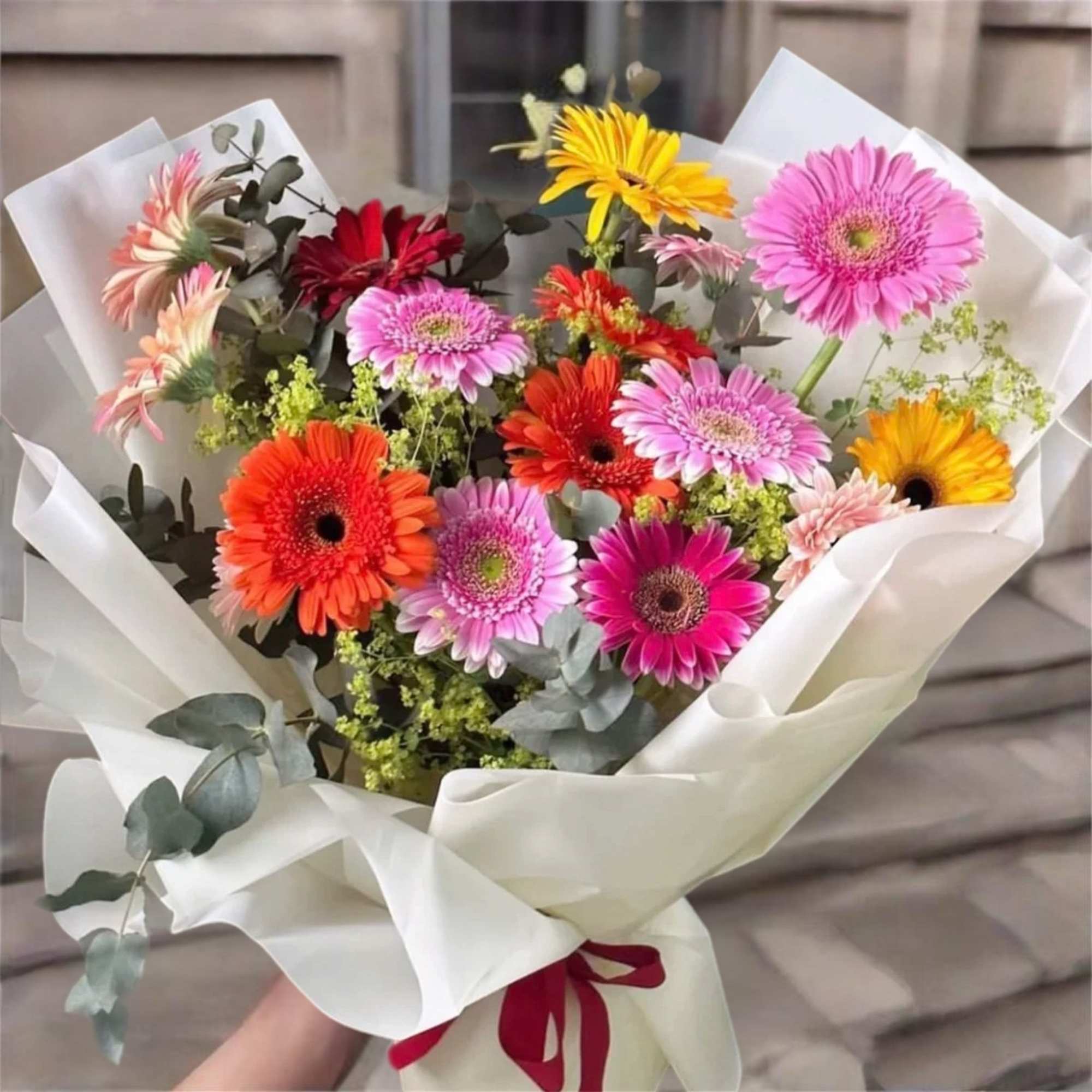 Bouquet of colorful gerbera daisies wrapped in white paper, photo 2 of 3