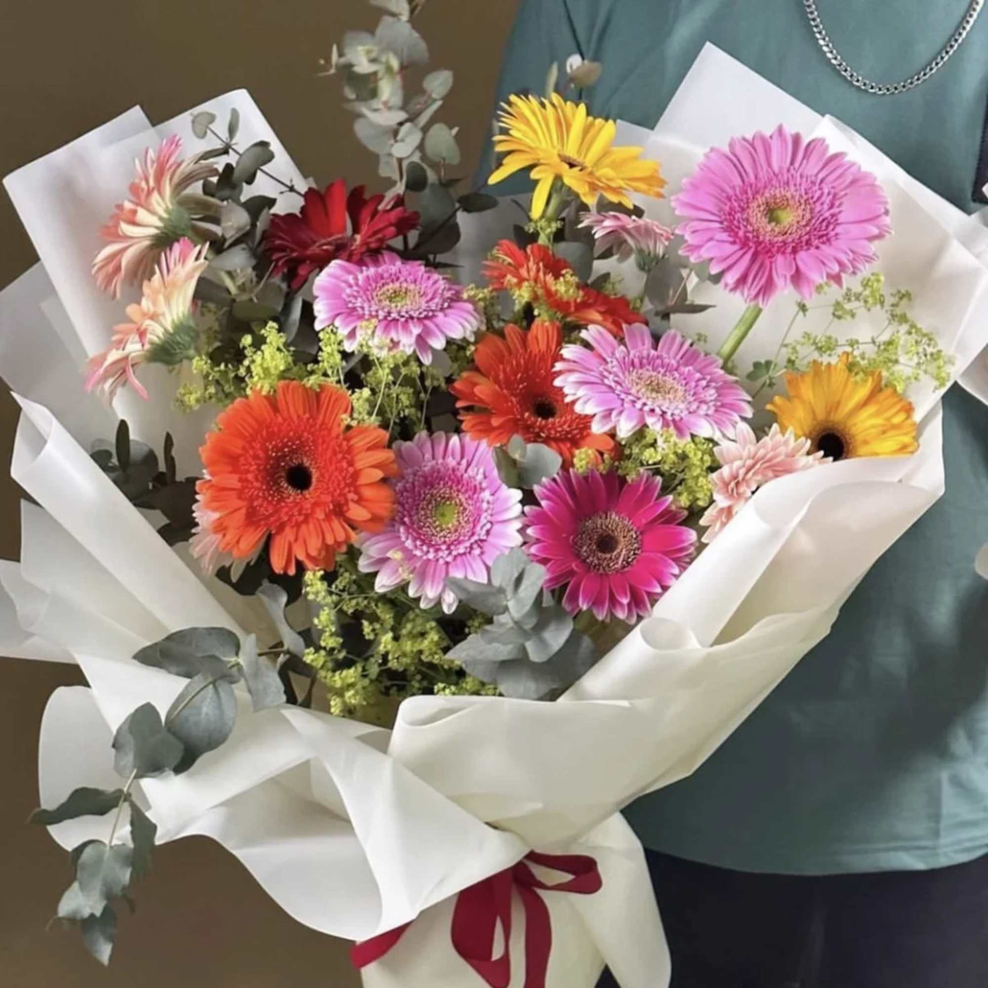Bouquet of colorful gerbera daisies wrapped in white paper, photo 3 of 3