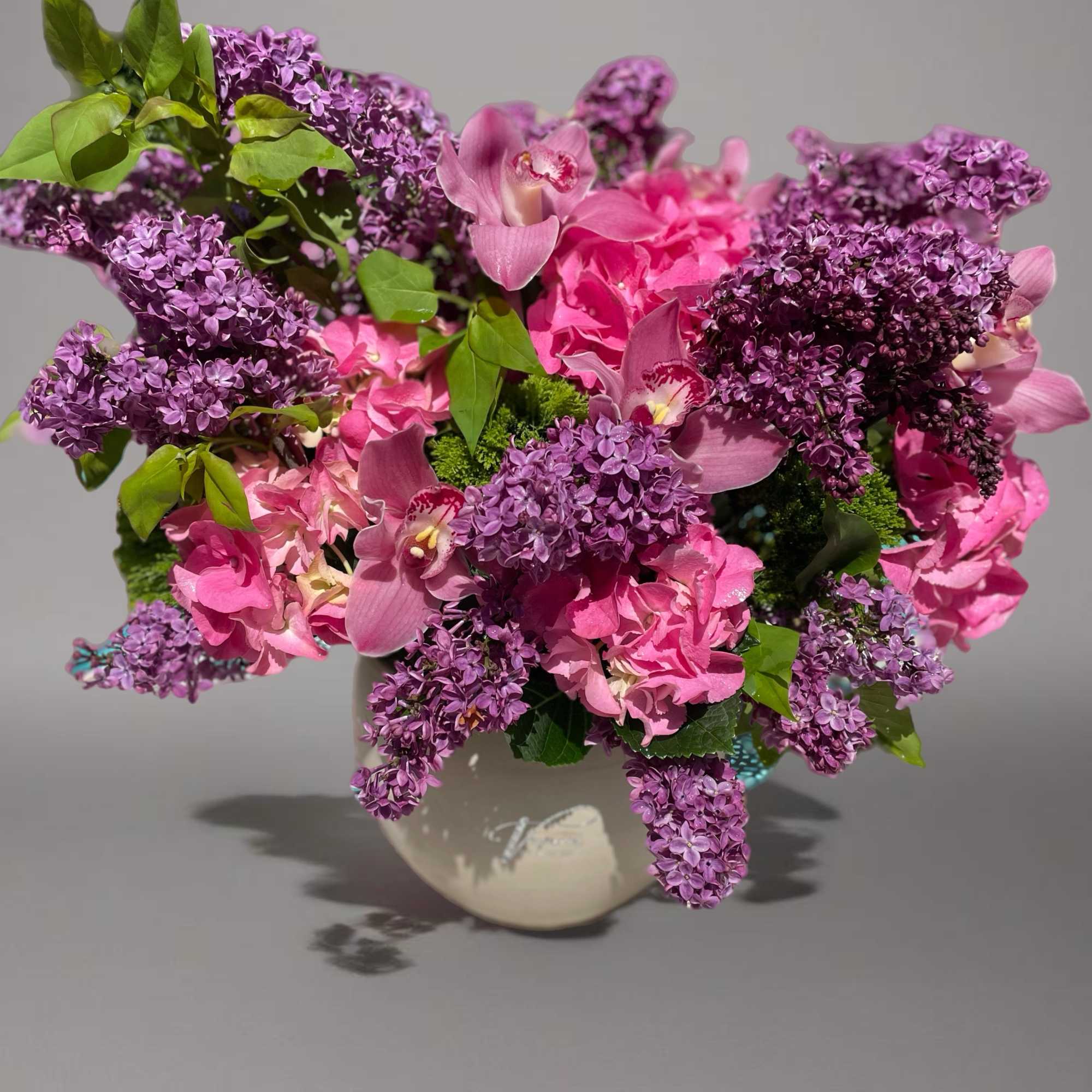 Pink and purple floral arrangement in a ceramic vase