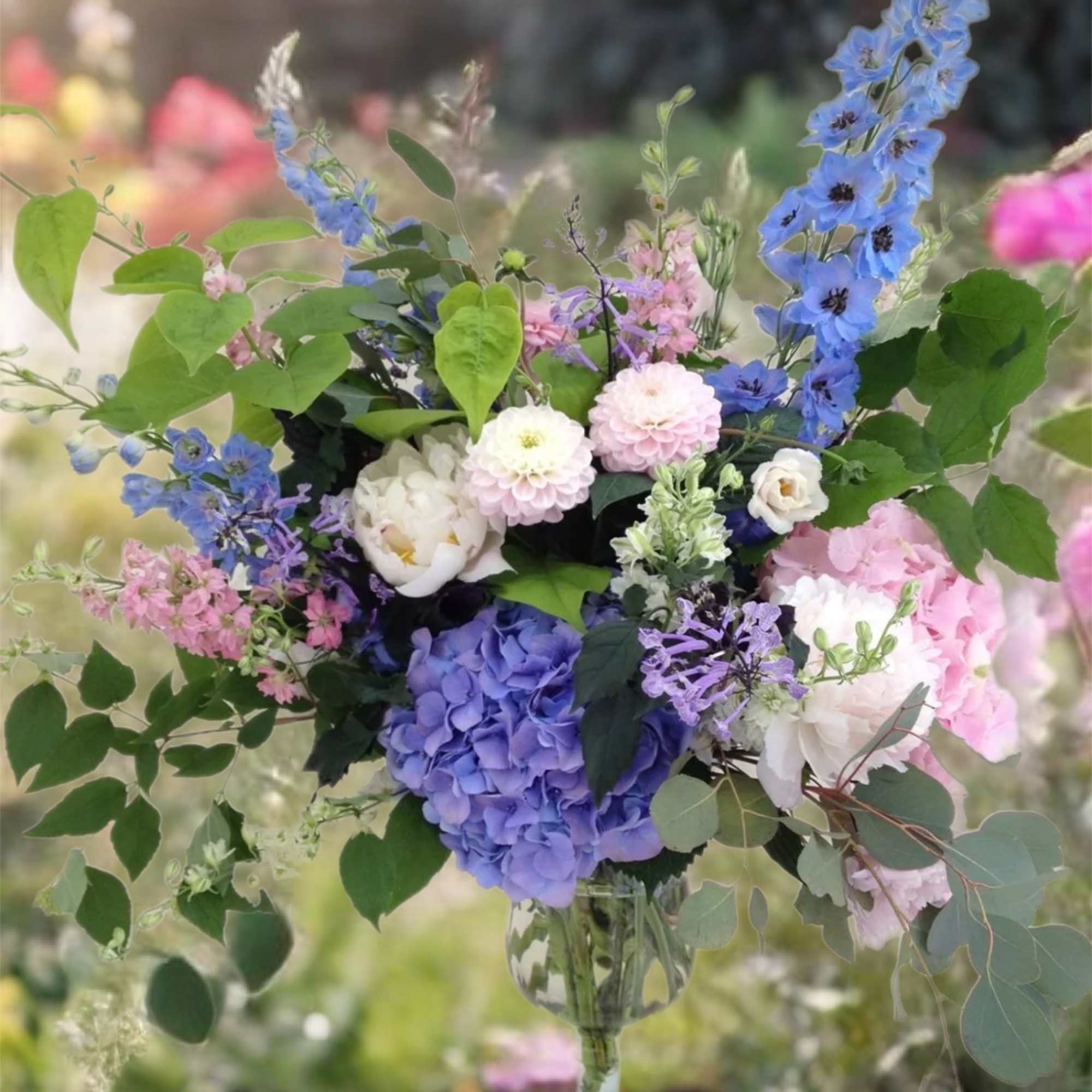 Mixed bouquet in a glass vase with blue, pink, and white flowers