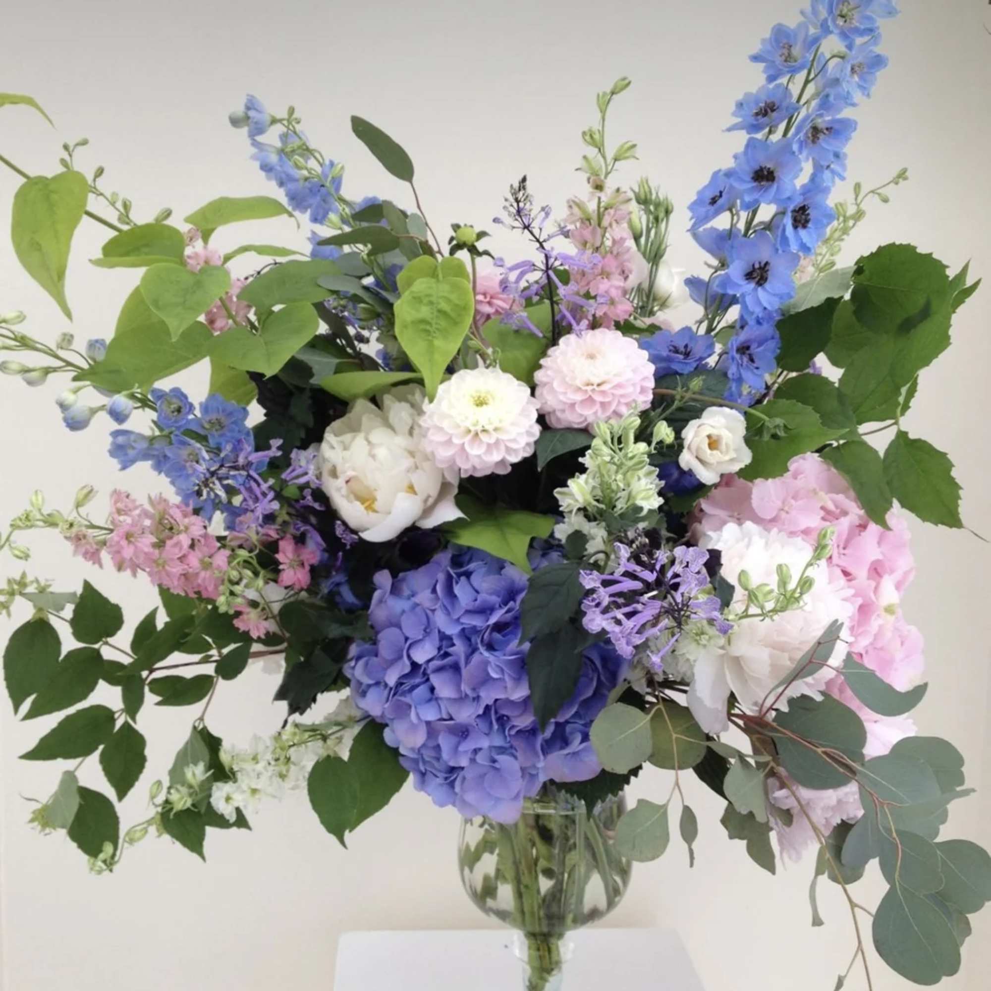 Blue and pink floral arrangement in a glass vase
