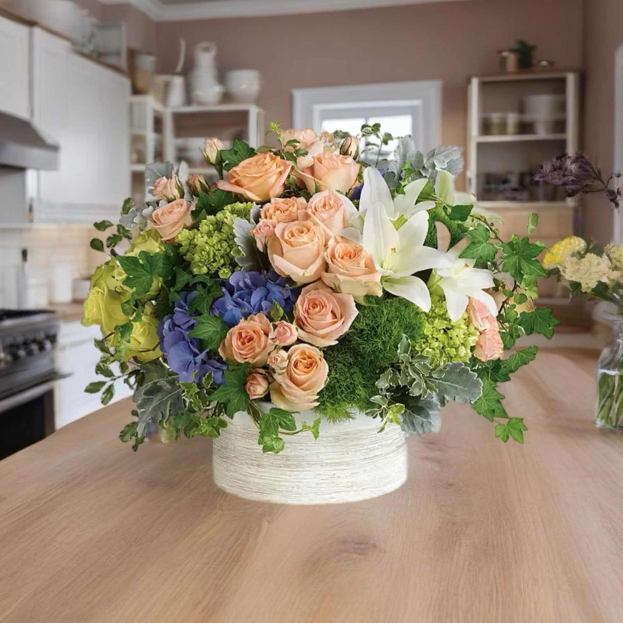 Mixed bouquet of peach roses, white lilies, and blue hydrangeas in a white vase, photo 5 of 5