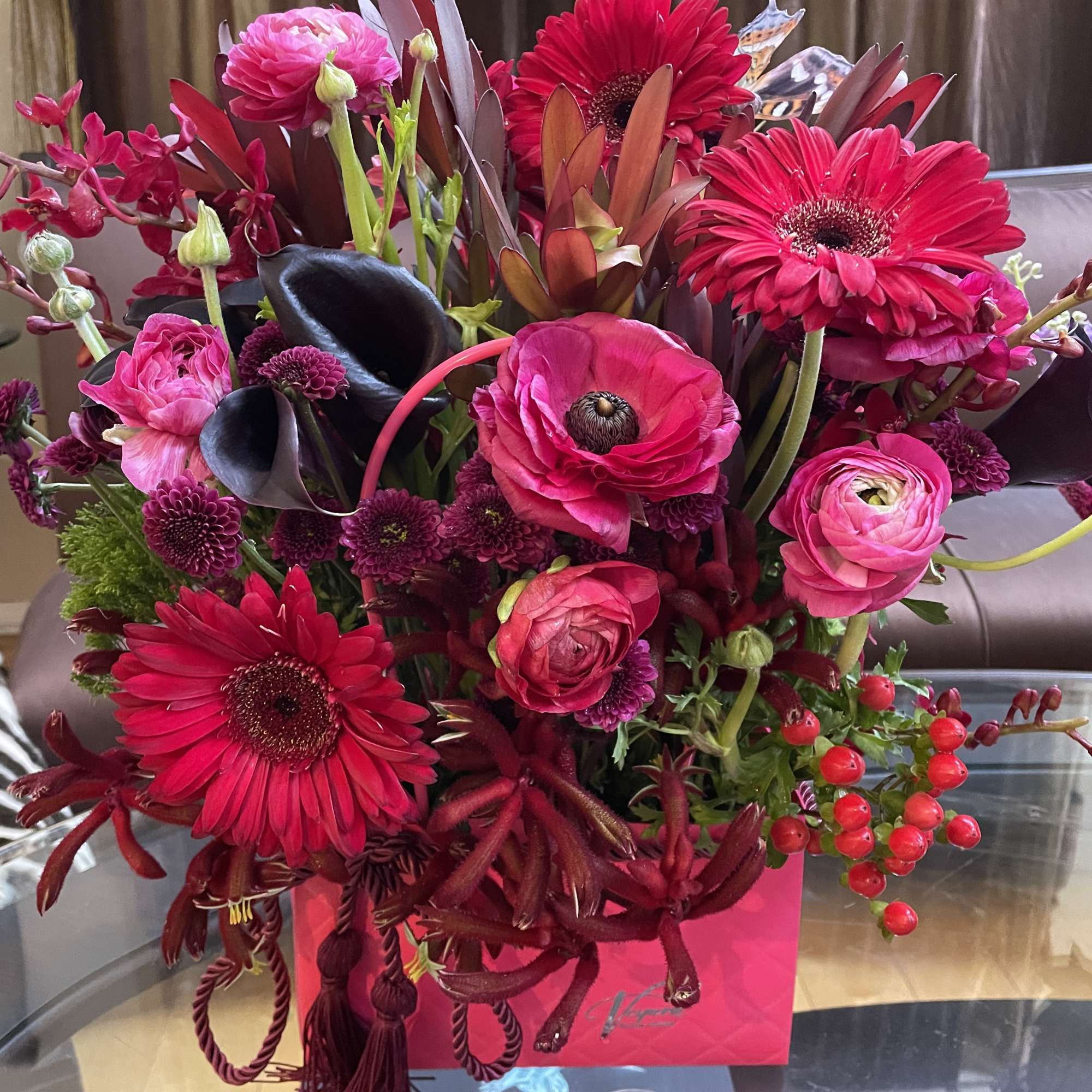 Bright pink and red mixed bouquet with gerbera daisies, ranunculus, and dark calla lilies