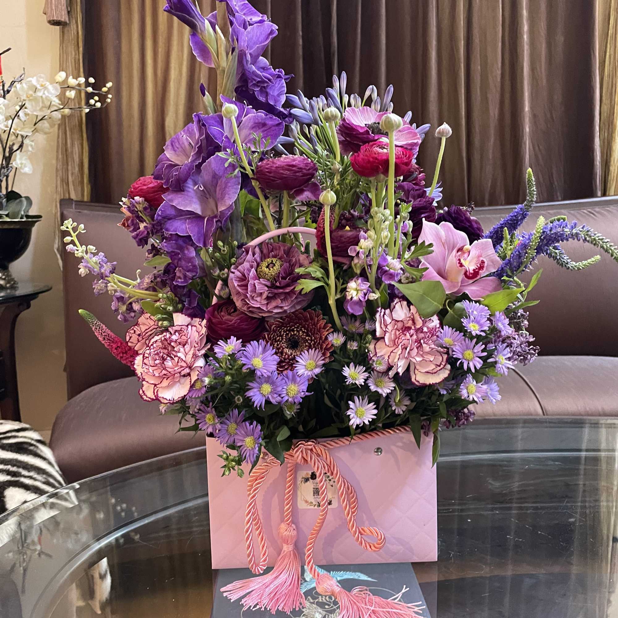 Purple and pink mixed bouquet in a pink gift box with tassel ribbon