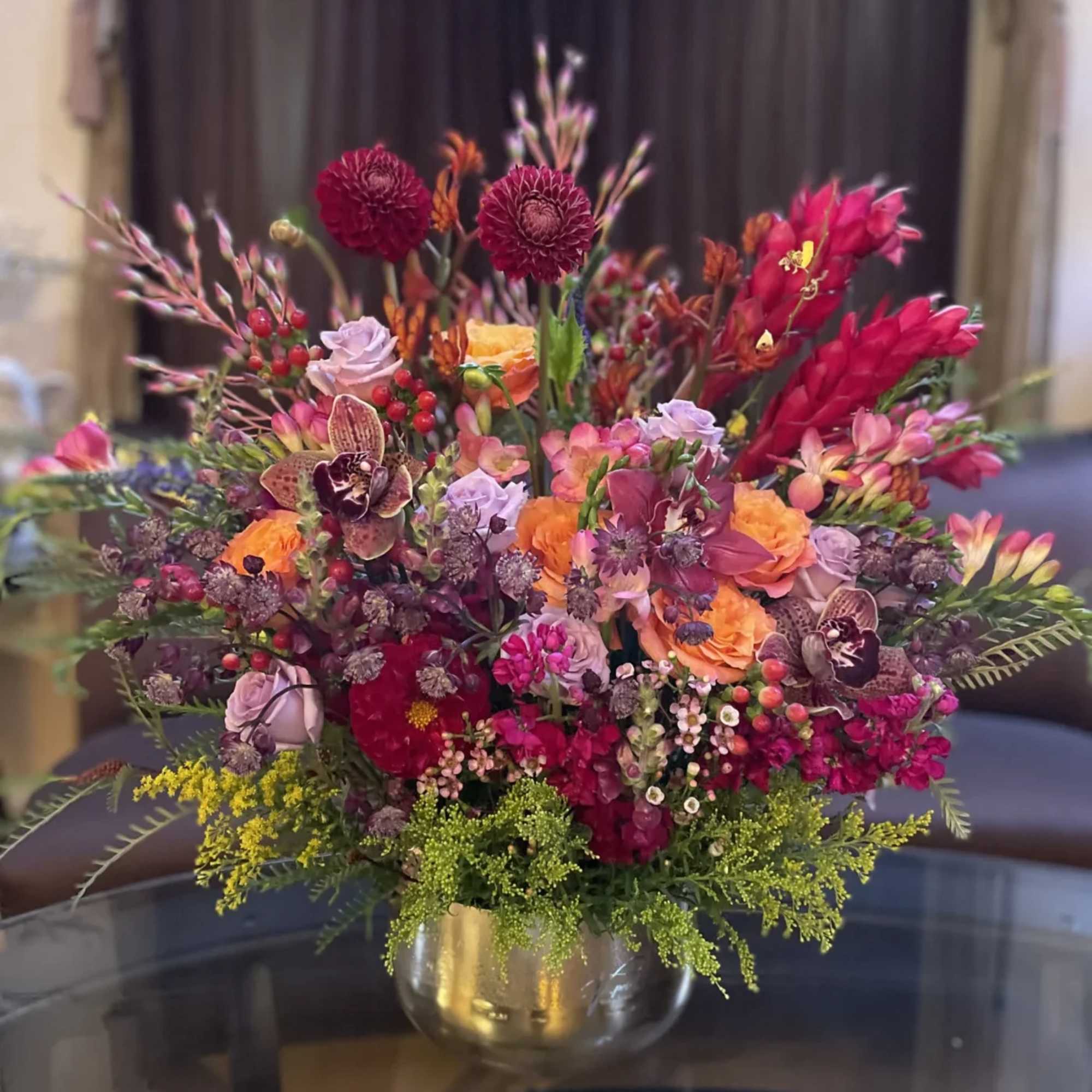 Colorful mixed flower arrangement in a gold vase