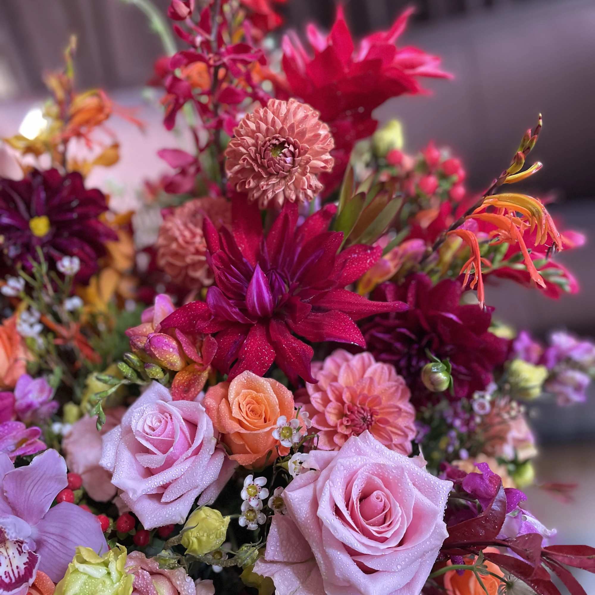 Colorful bouquet of roses and dahlias in pink, orange, and magenta