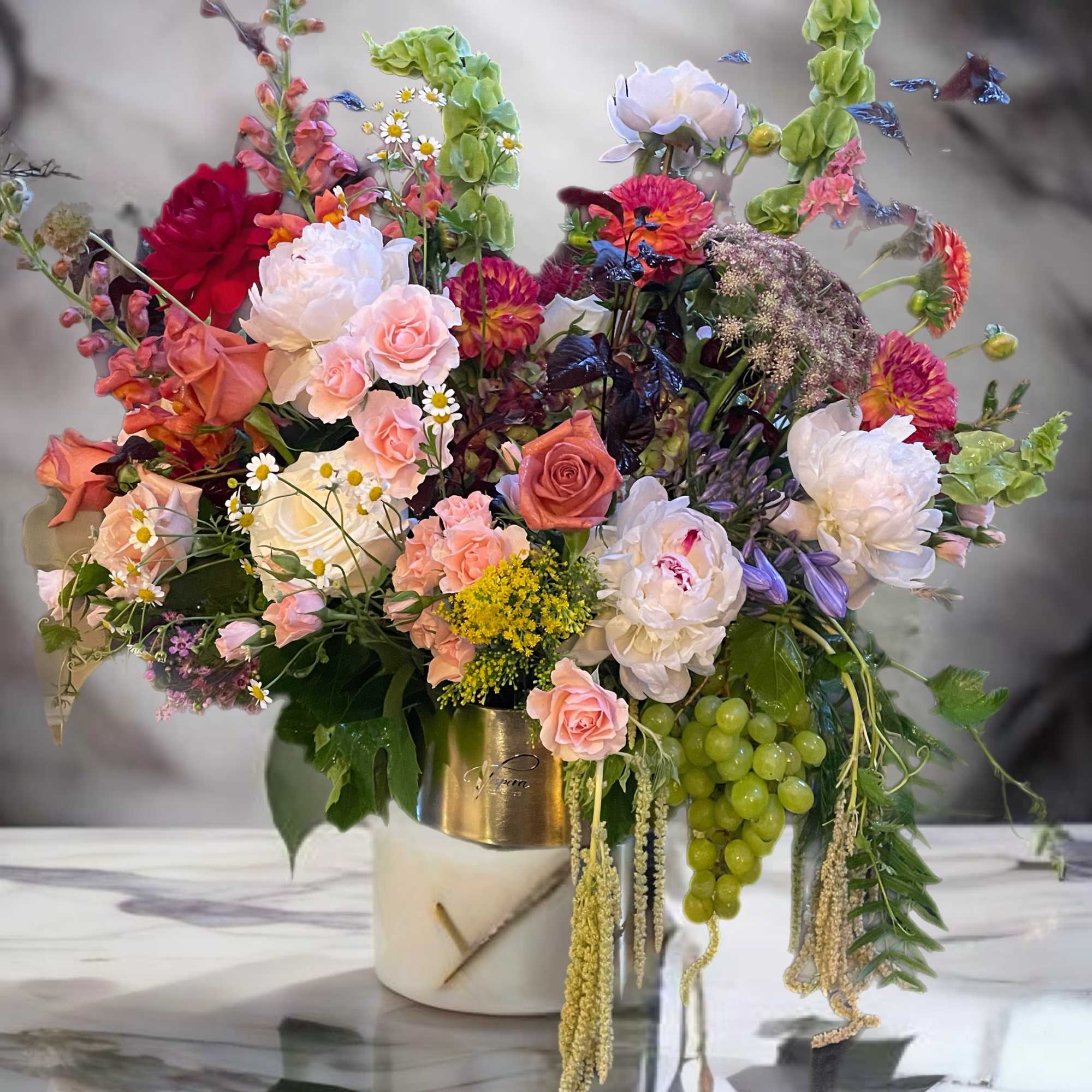 Mixed bouquet of pink, white, and red flowers in a white vase
