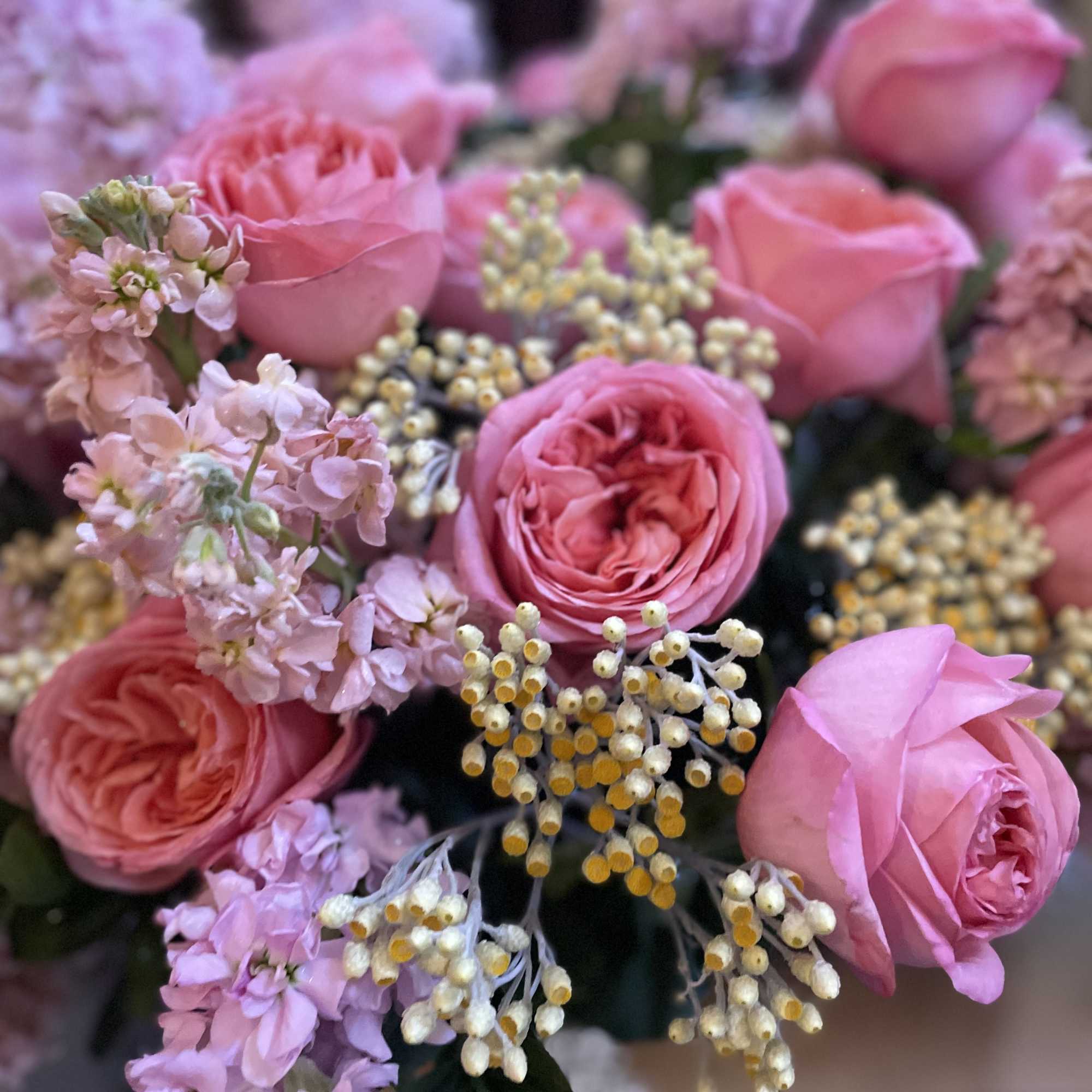 Pink roses with pale lavender filler flowers in a bouquet