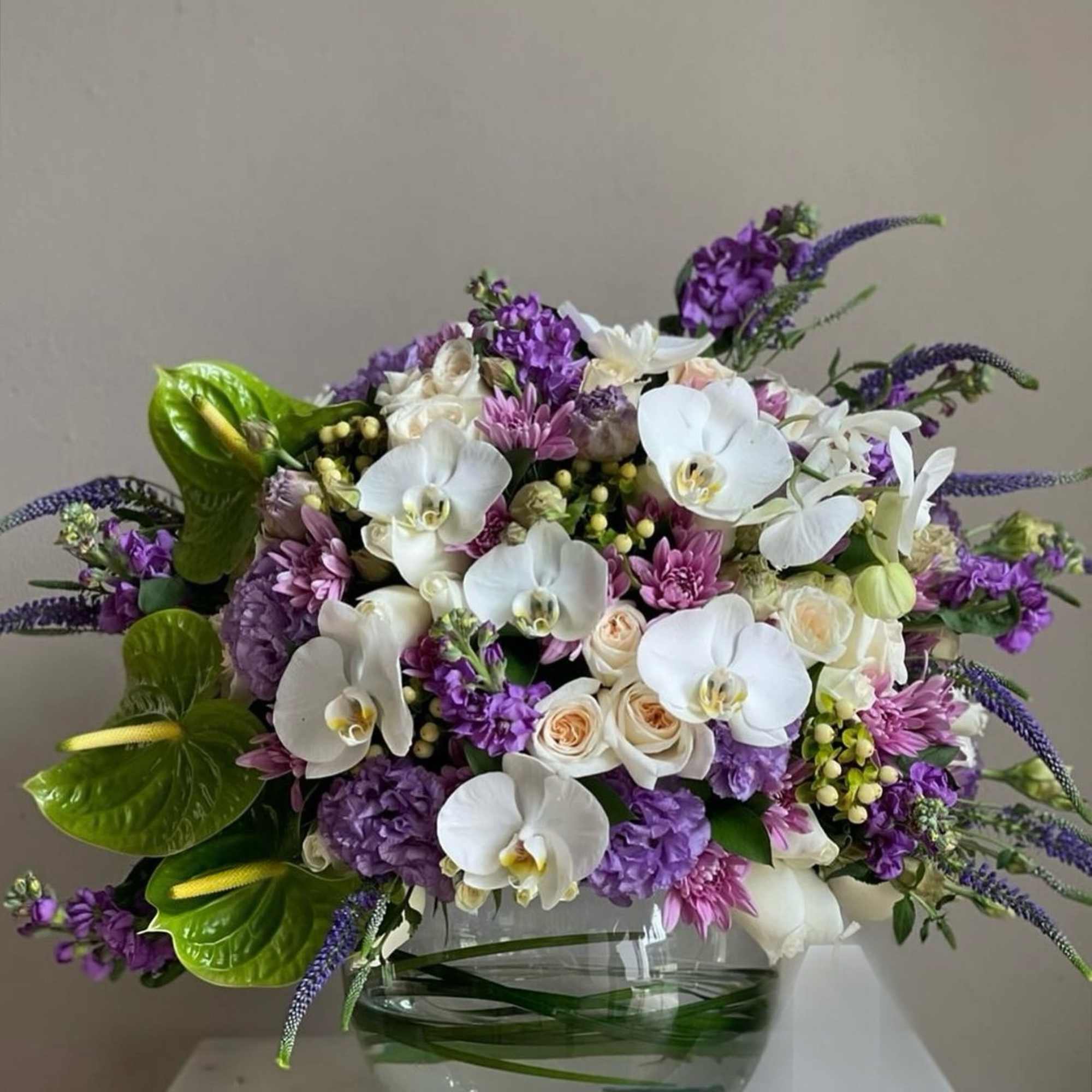 Purple and white floral arrangement in a glass bowl vase, photo 2 of 2