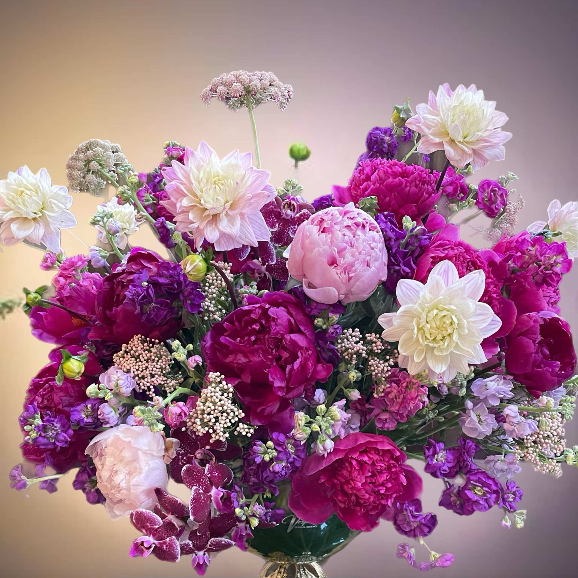 Large bouquet of pink, purple, and white flowers in a decorative vase
