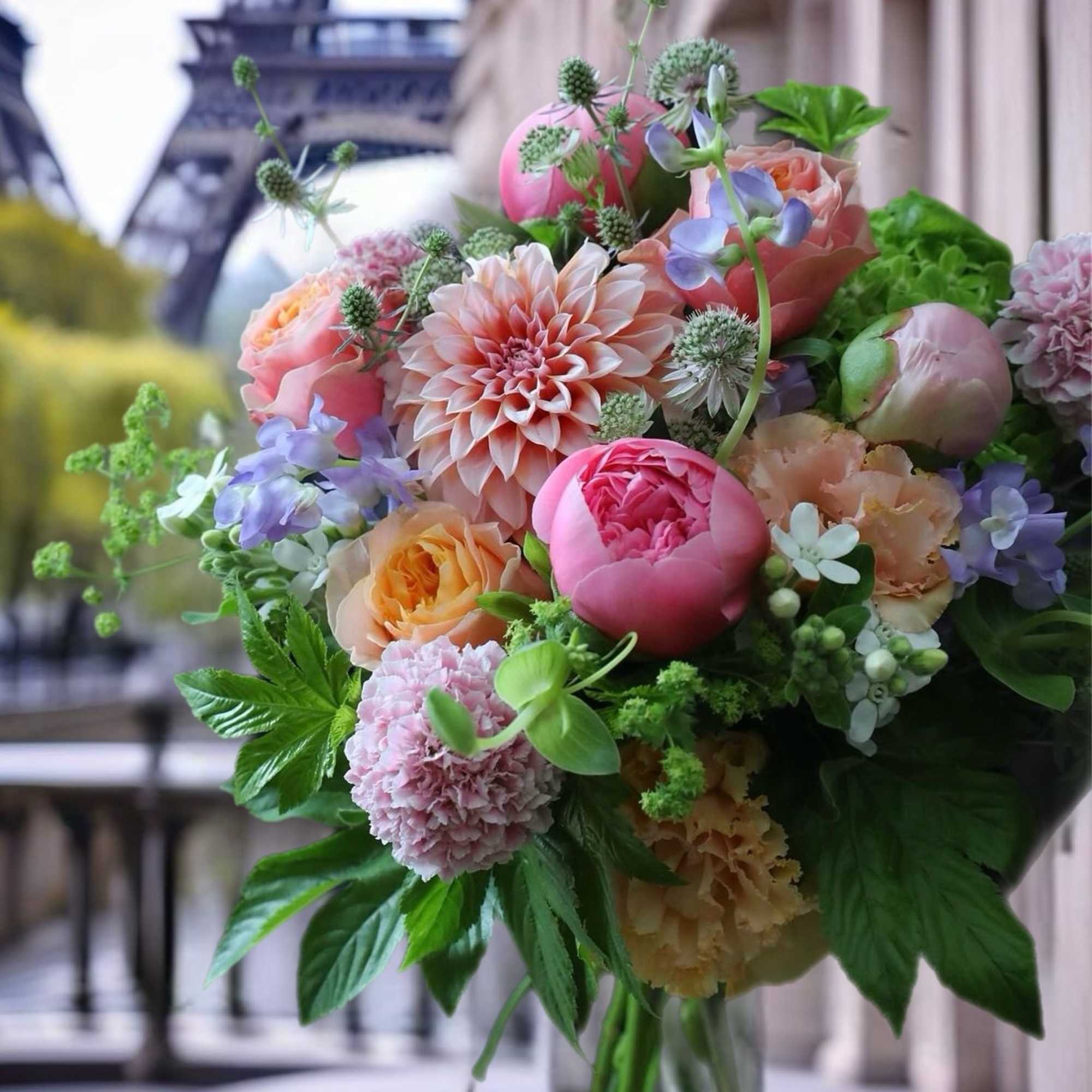 Bouquet of pink, peach, and lavender flowers with greenery