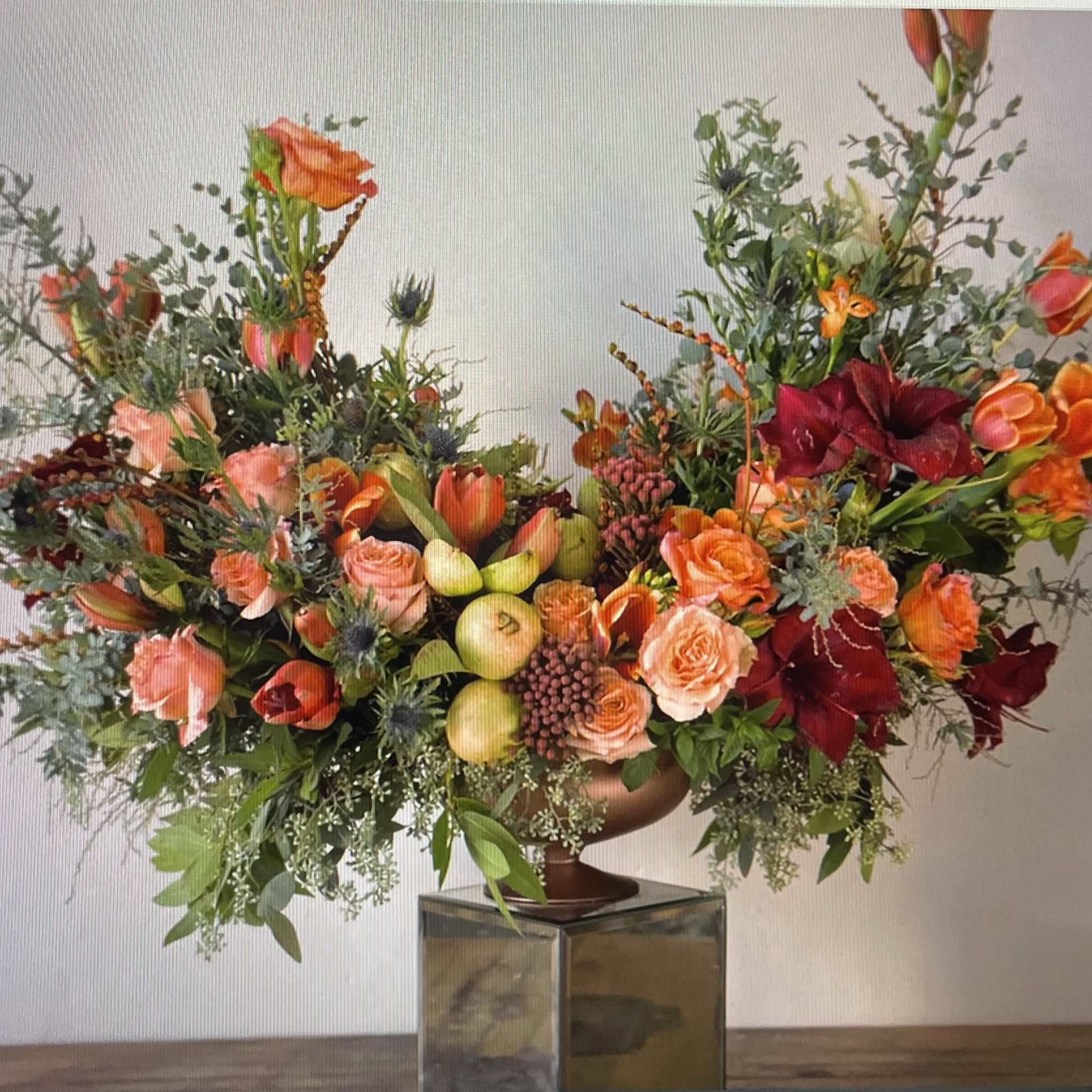 Large floral arrangement with orange and red blooms in a vase